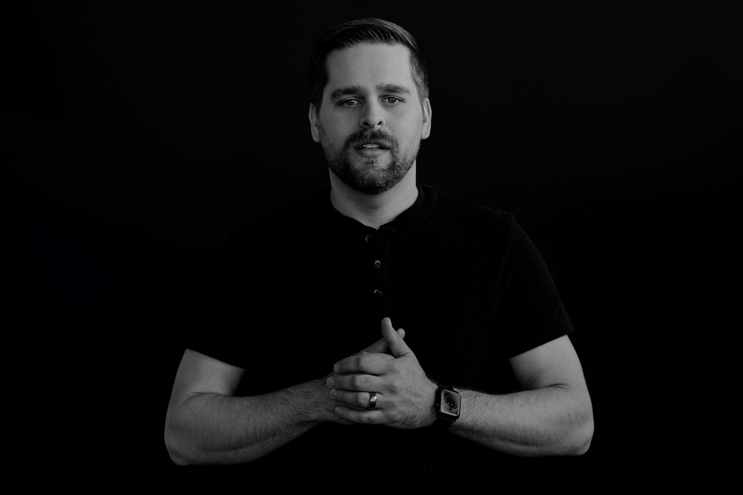 Black and white portrait series showing a person in a dark shirt against a dark background.
