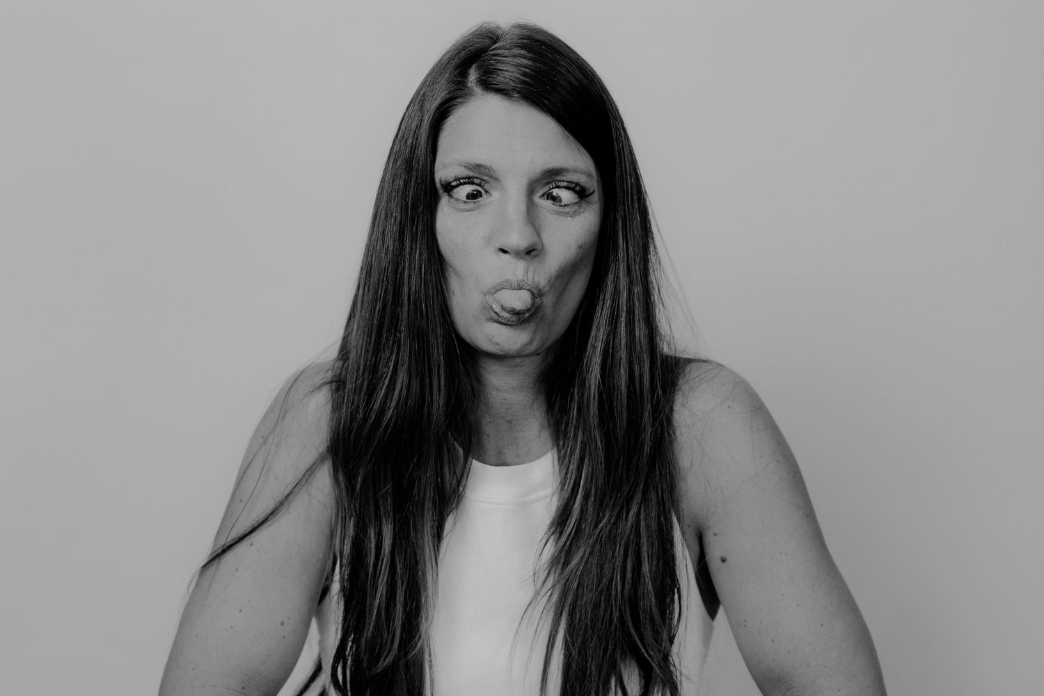 Black and white portrait series showing contemplative expressions in white top.