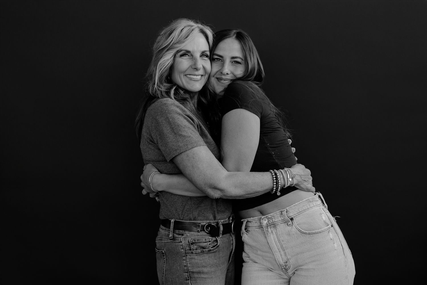Emotional black and white portrait captures warm embrace between two women.