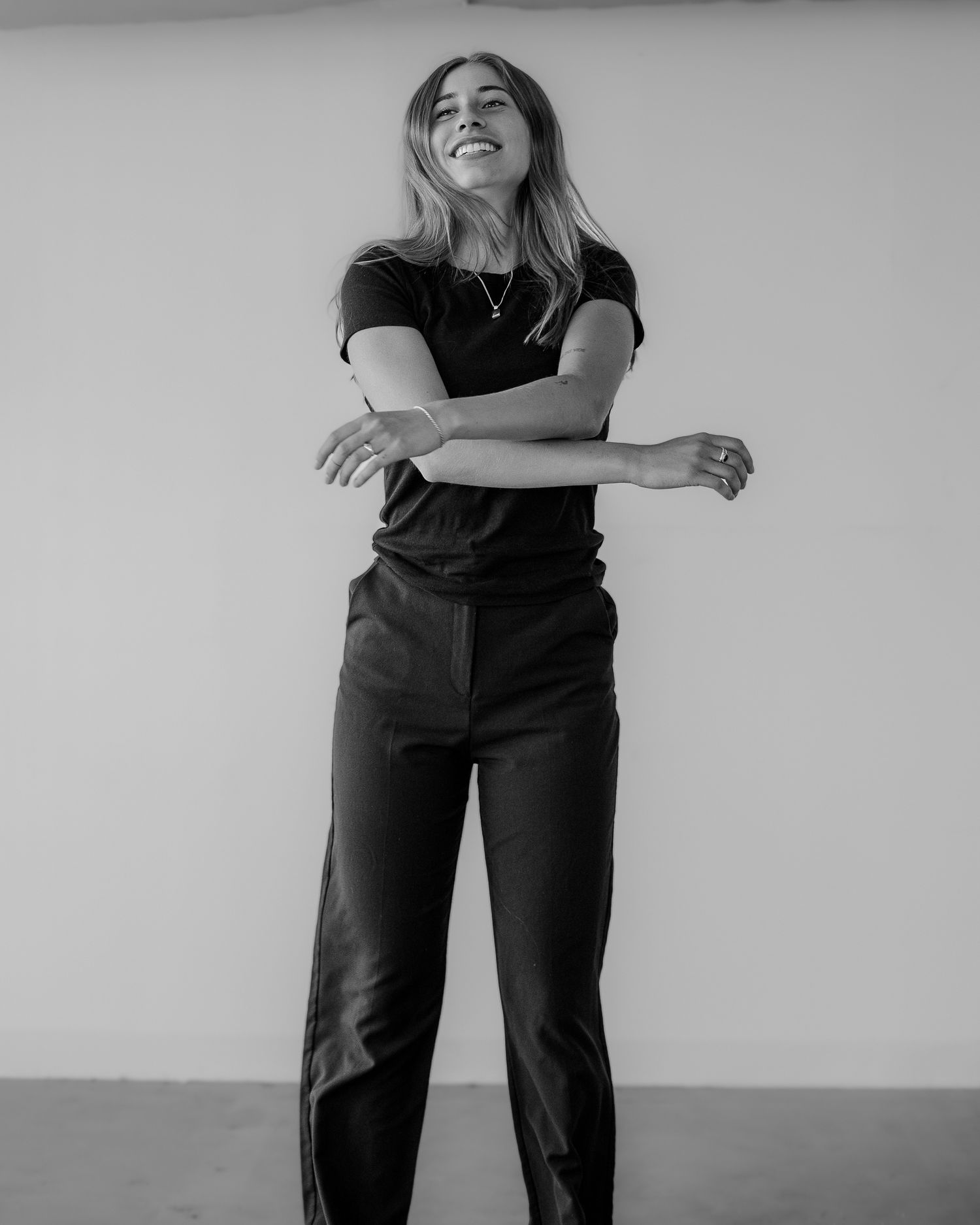 Person in dark clothing moves playfully through dance-like poses in monochrome series.