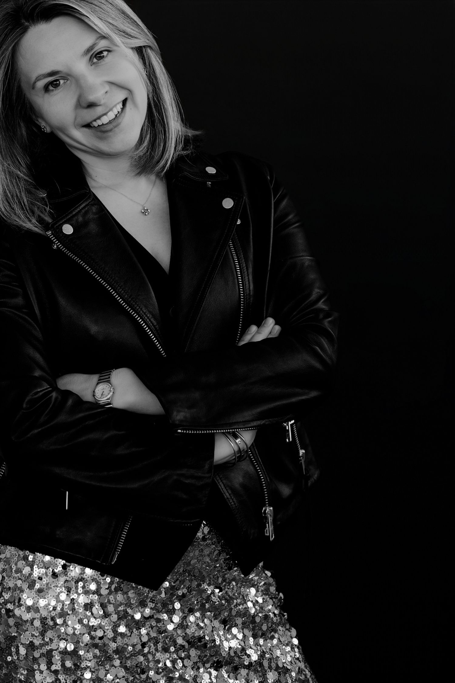 Moody portrait with leather jacket and sequin details in dramatic studio lighting.