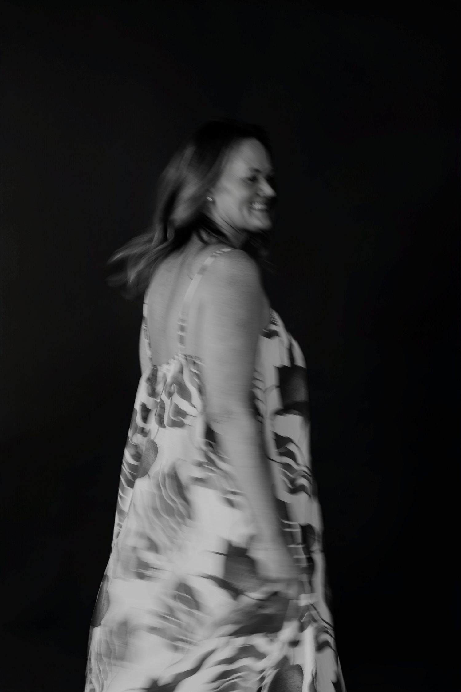 Motion-blurred black and white photographs capturing spinning movement in floral dress.