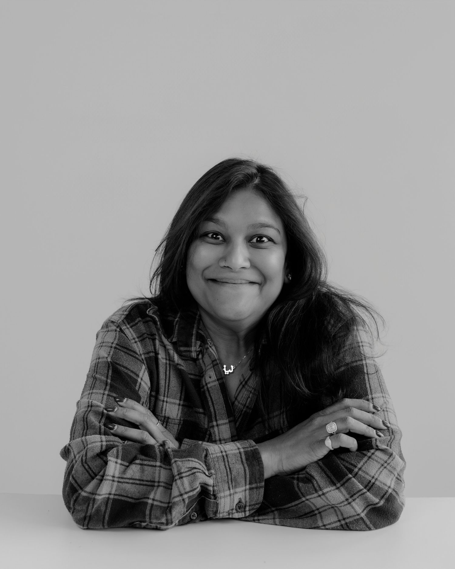 Person in plaid shirt lying down showing playful expressions in grayscale series.