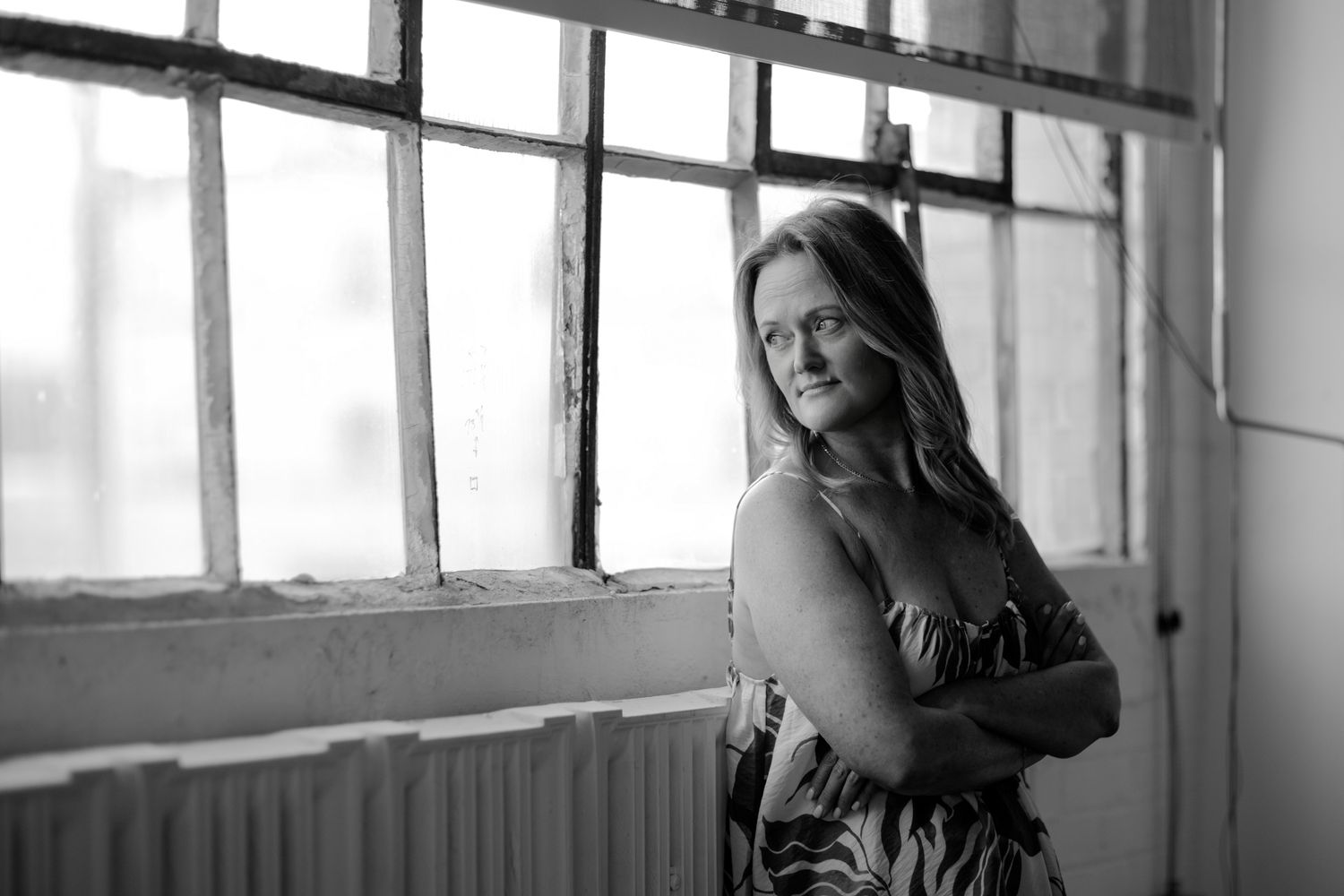 Artistic portraits taken near industrial windows showing contemplative poses in natural light.