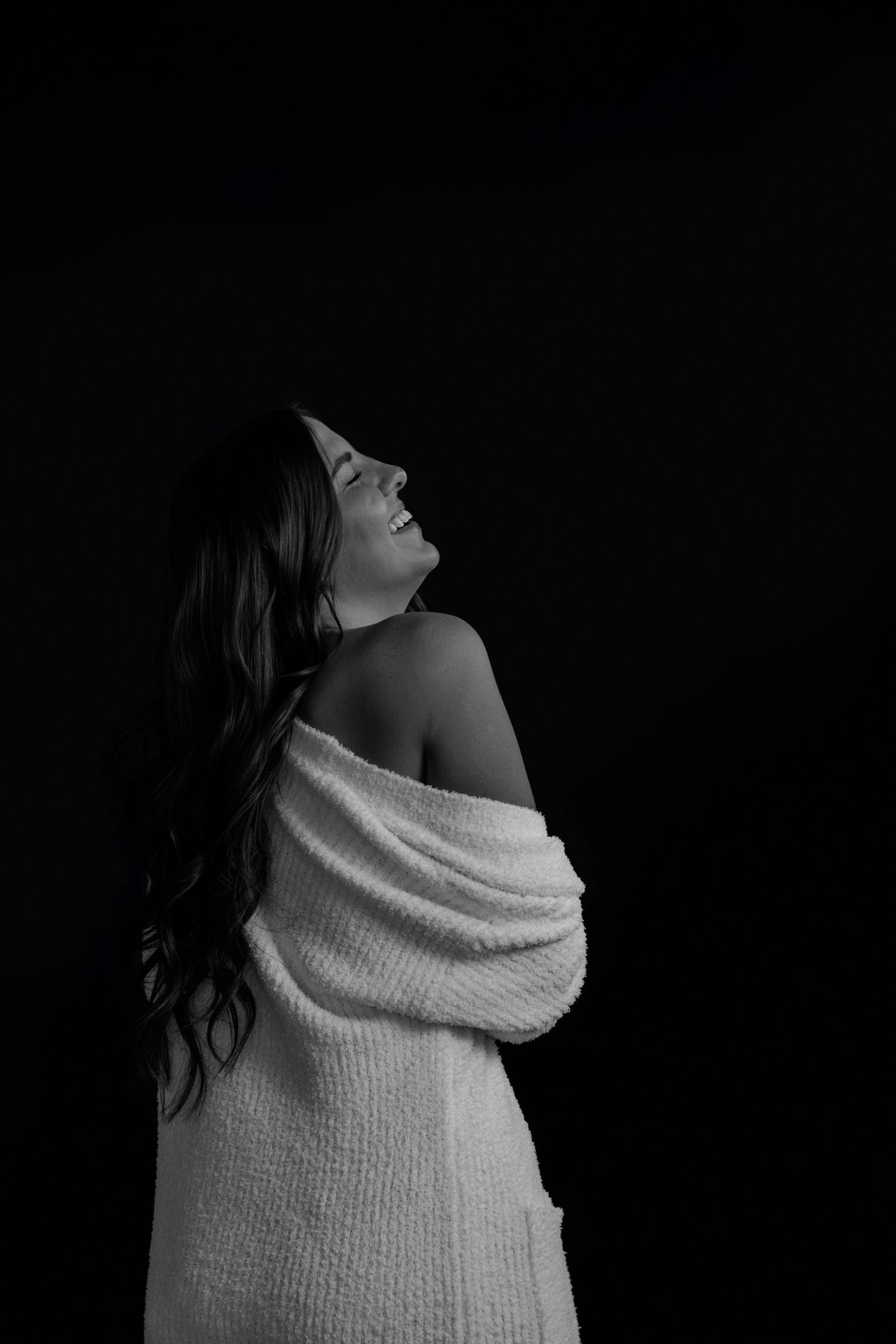 Artistic black and white photos featuring white wrapped sweater in dramatic lighting.