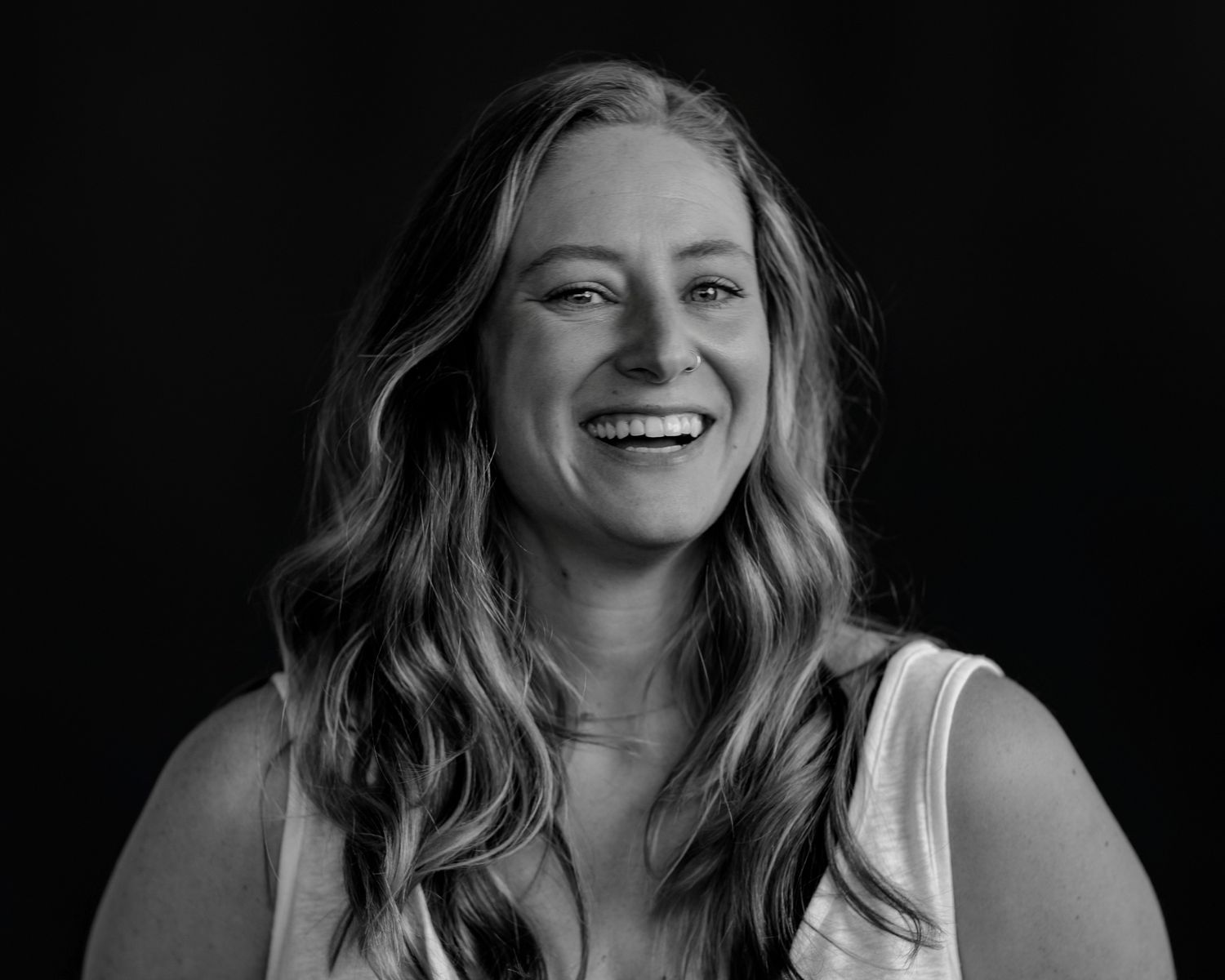 Black and white studio portraits capturing candid laughter and genuine expressions.