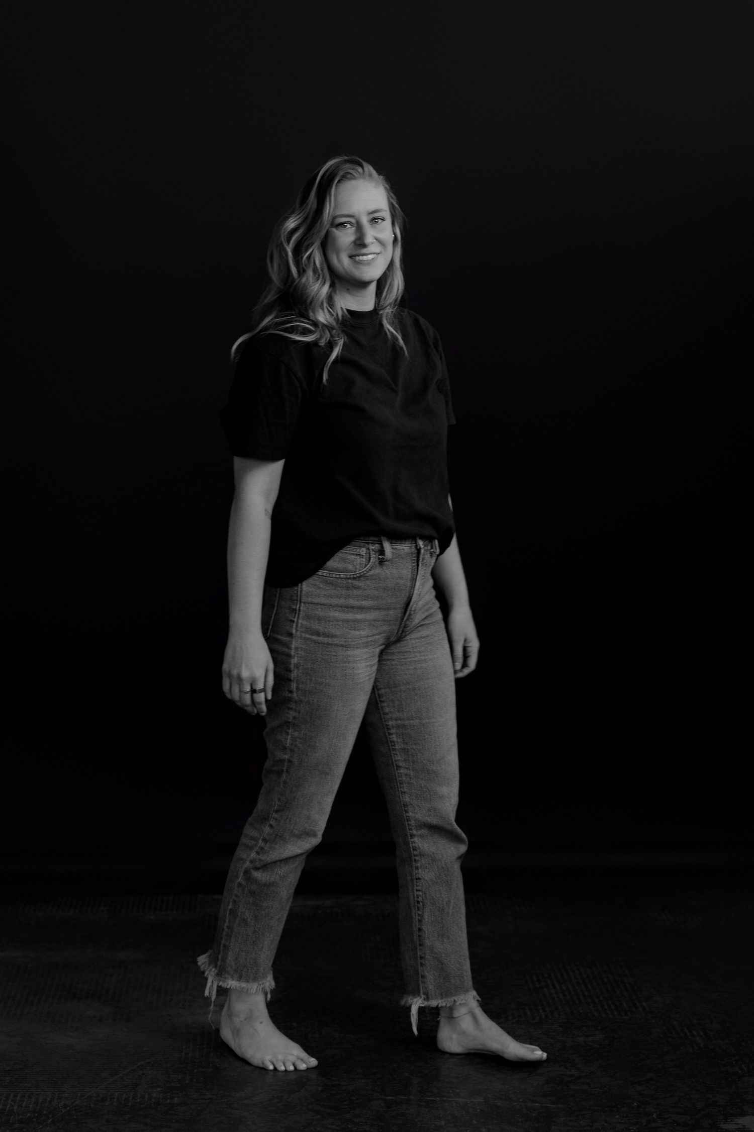 Casual portrait series showing person in black top and jeans with relaxed poses.