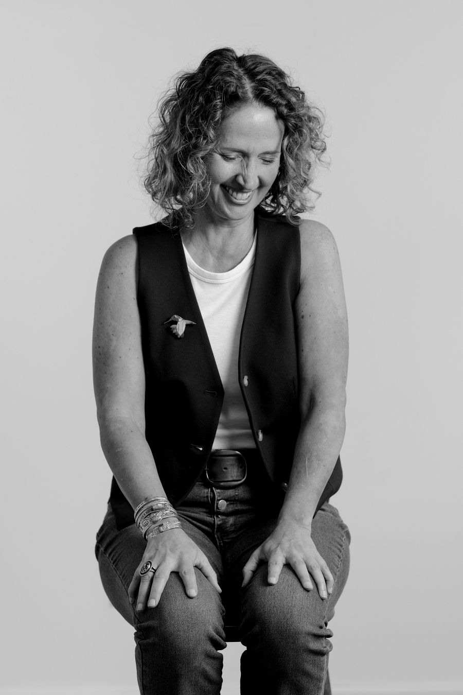 Portrait series showing relaxed poses in black vest against light background.
