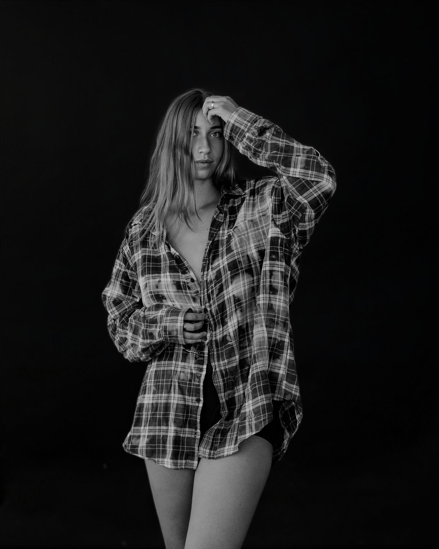 Black and white portrait series showing someone in a plaid flannel shirt against dark background.