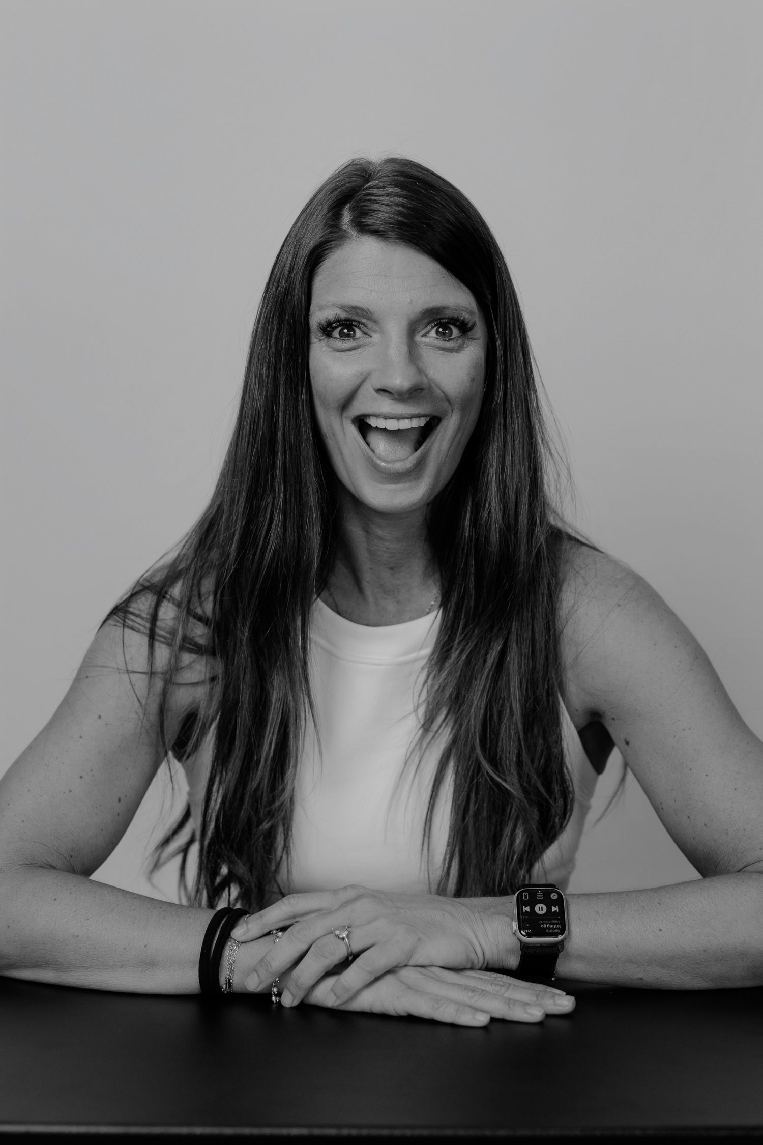 Black and white photo sequence capturing playful expressions and gestures at a dark table.