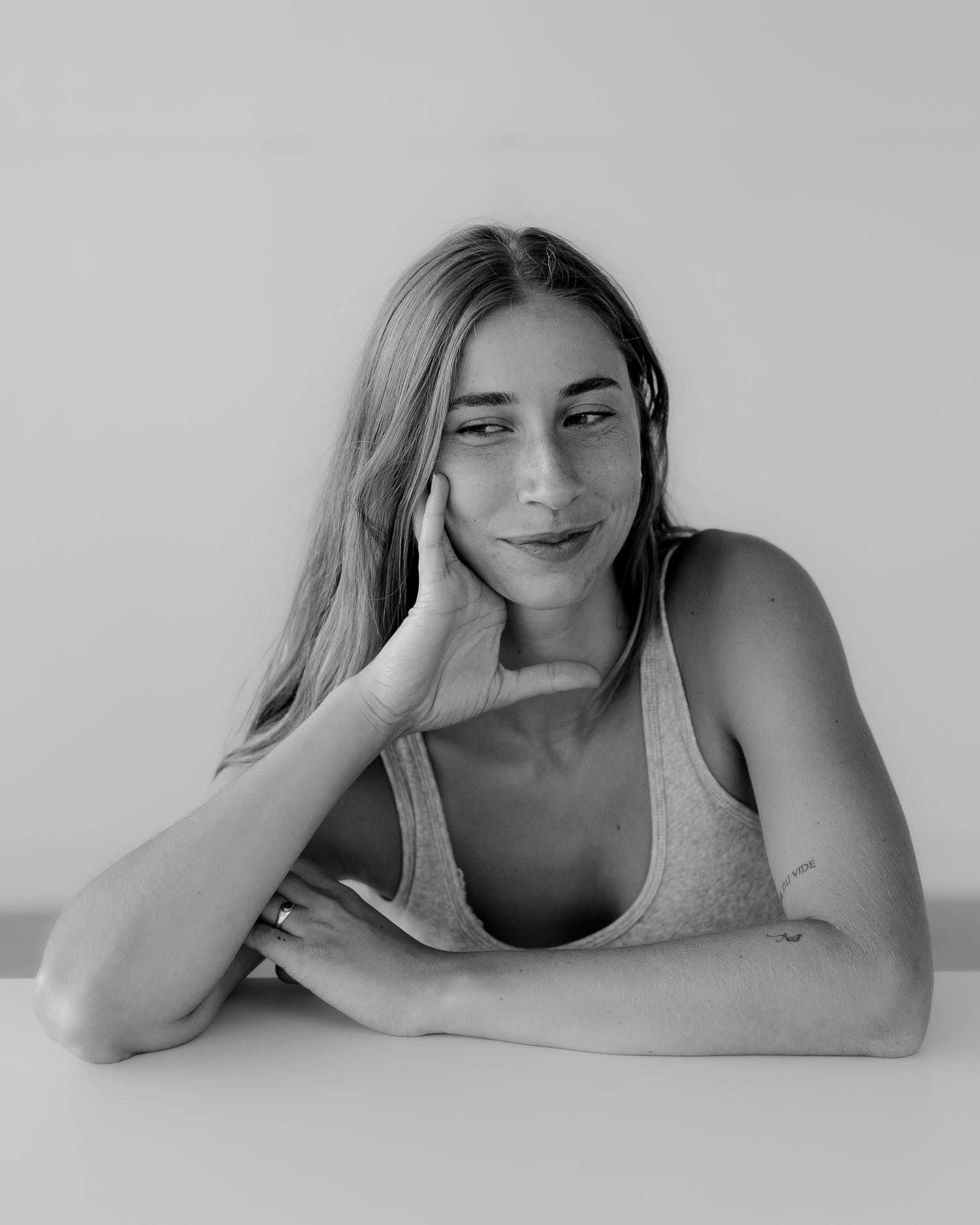 Artistic black and white photo series showing relaxed poses on a white surface.