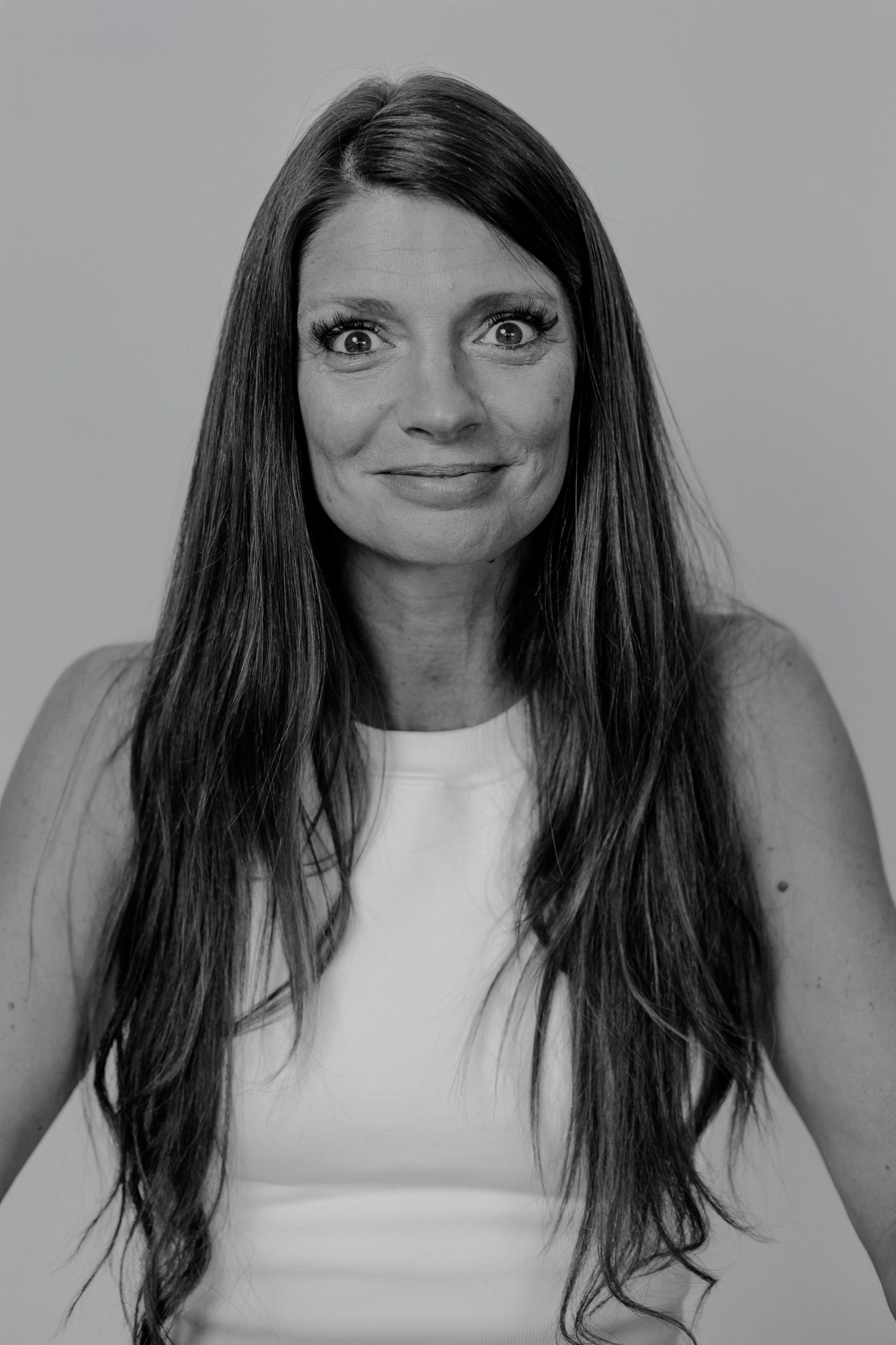 Black and white photo sequence showing changing expressions in white sleeveless top.