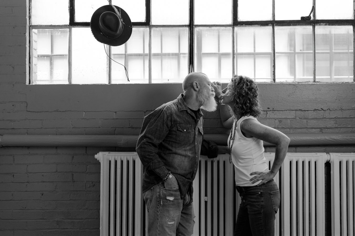 Dance performance photographed against industrial windows showing fluid partner movements.