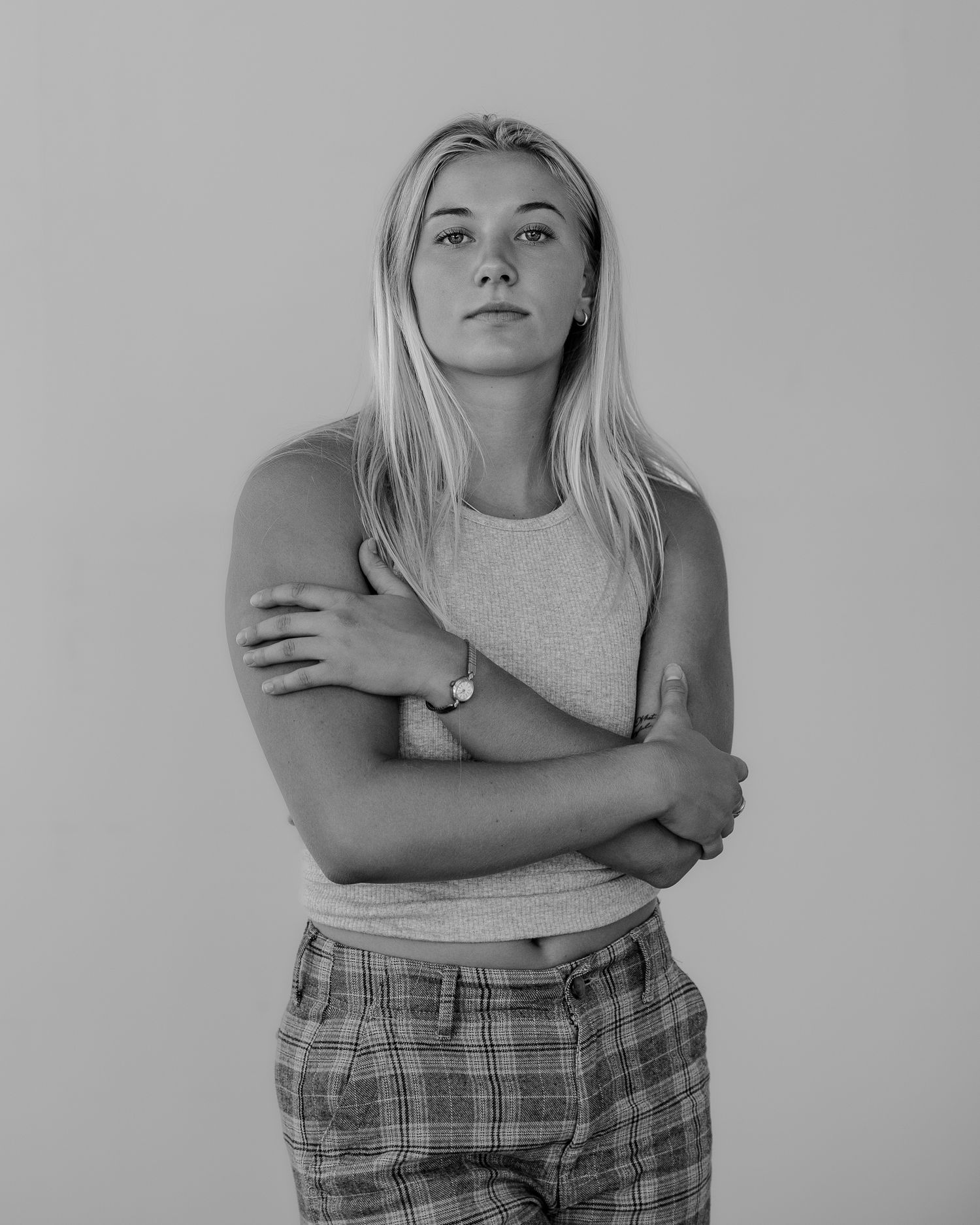 Monochrome portrait series showing person in casual wear with crossed arms in various poses.