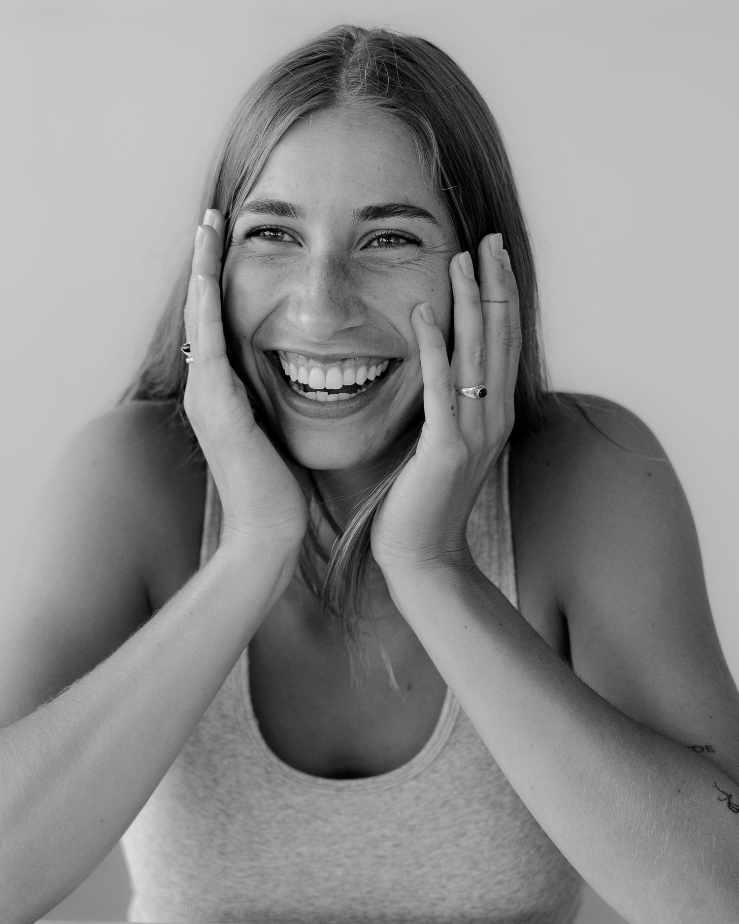 Black and white portraits showing expressive emotions and smiles against a light background.
