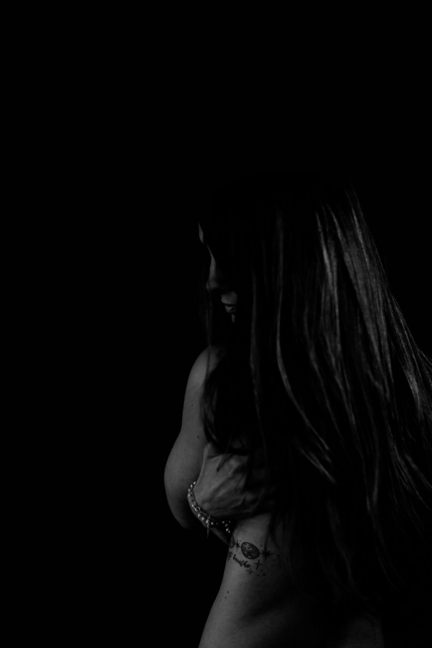 Intimate portrait series captured in dark moody lighting with natural expressions.