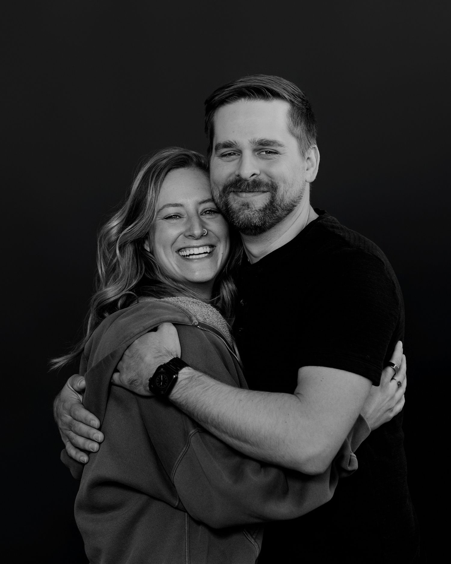 Black and white portrait showing genuine joy between embracing couple.