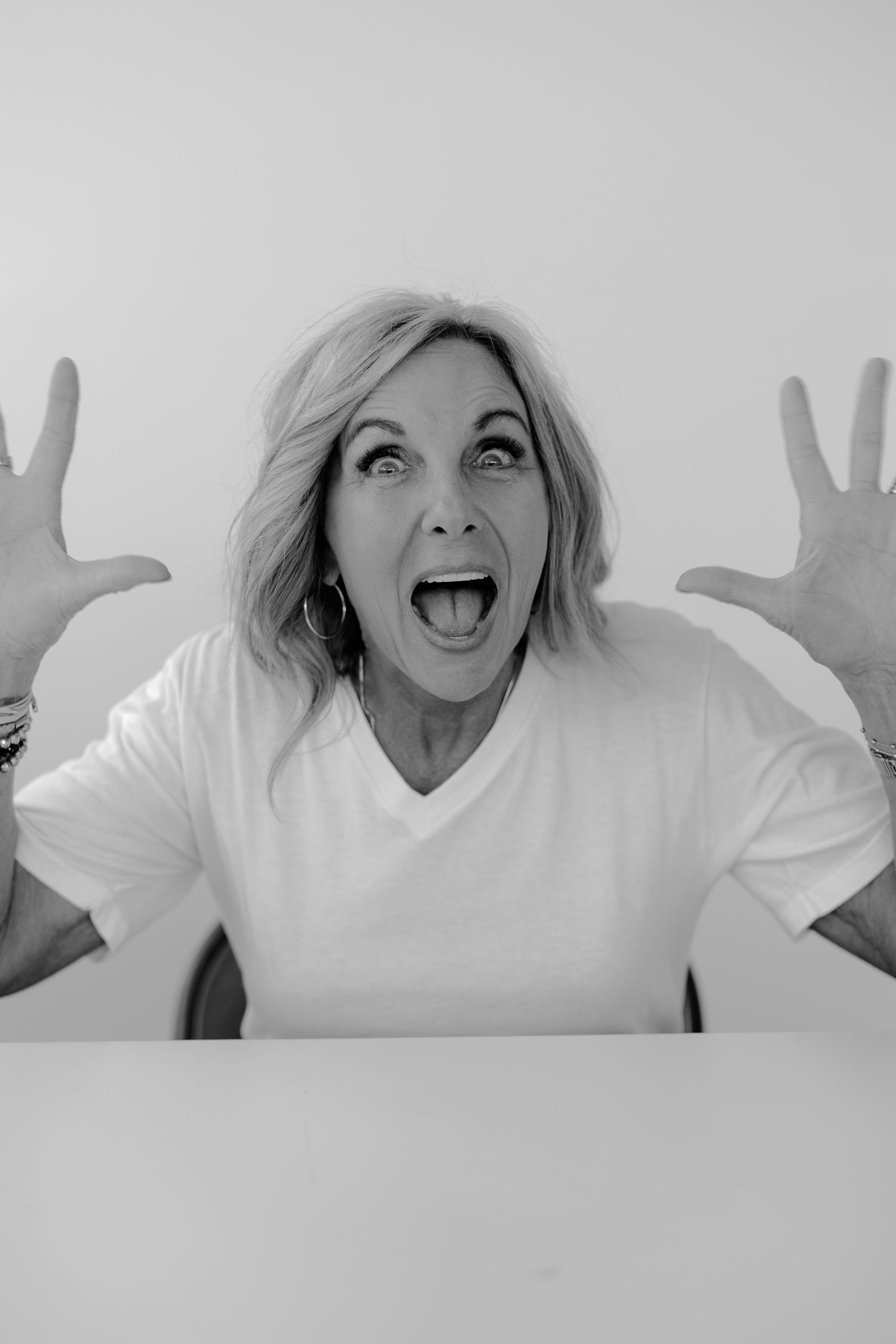 Expressive black and white portraits showing animated gestures in white top.