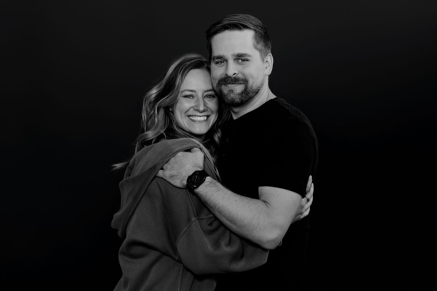 Intimate black and white portrait of couple embracing and laughing together.