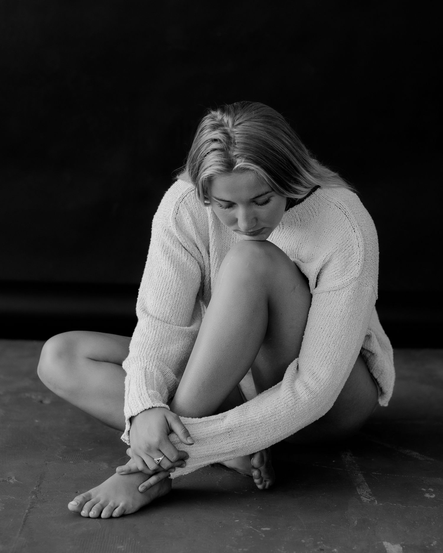 Artistic black and white series showing person in white clothing in expressive floor poses.