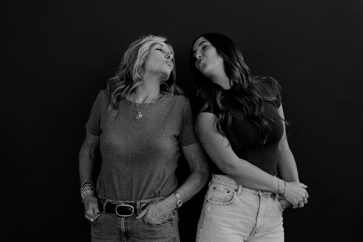 Candid black and white photo shows two women sharing an authentic moment of connection.