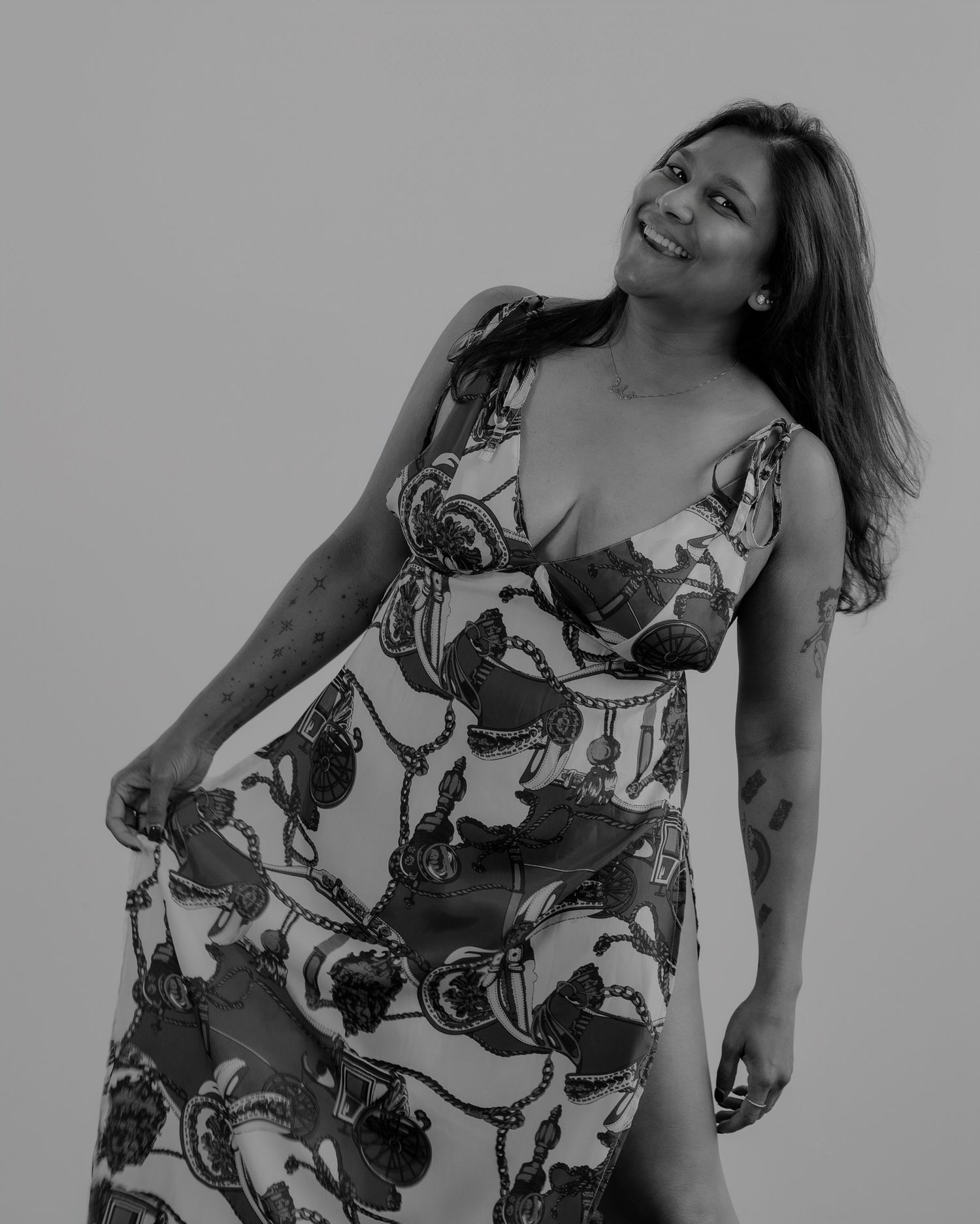 Grayscale photo sequence capturing playful movements in a patterned summer dress.