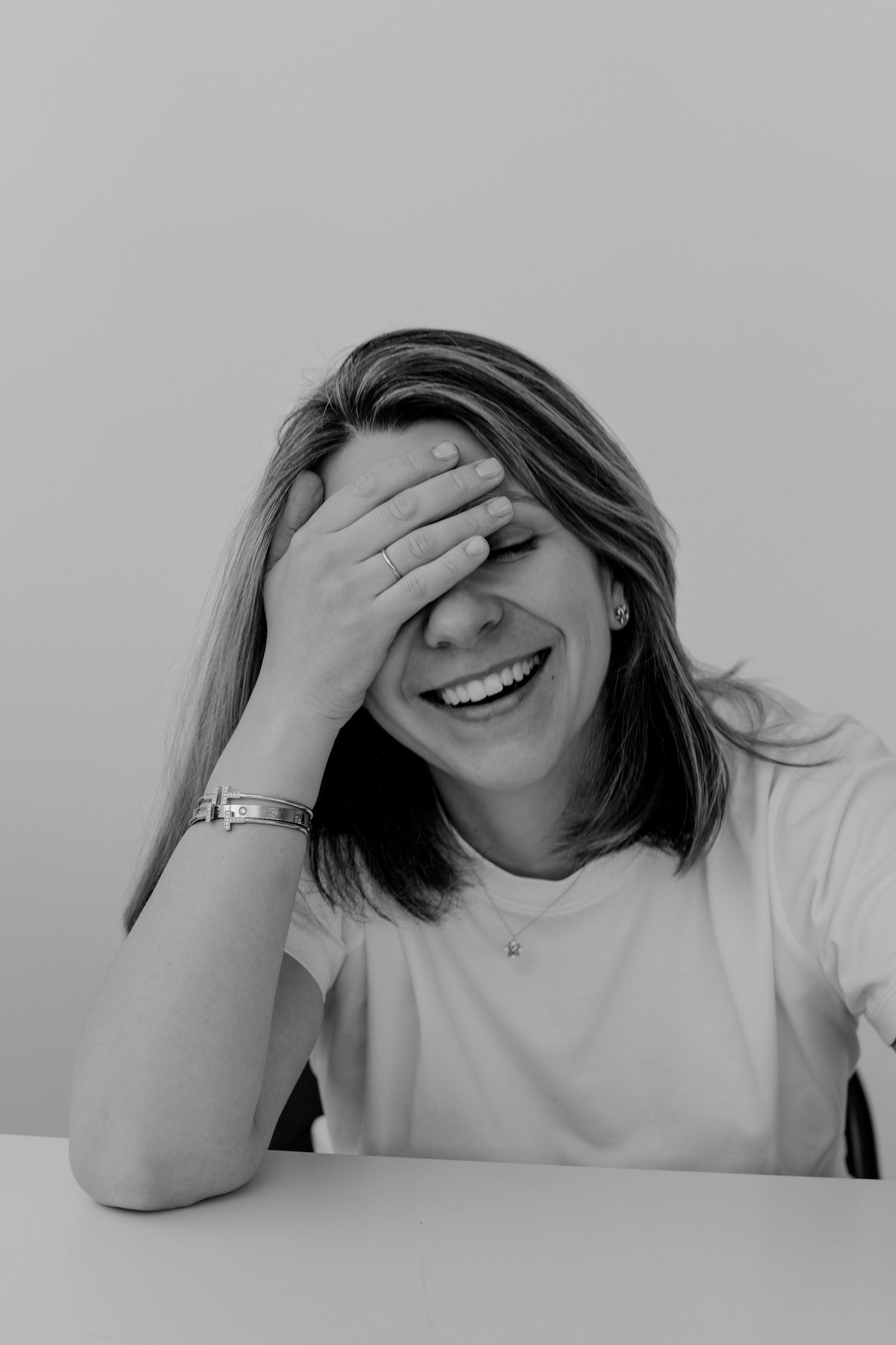 Black and white sequence showing laughter and playful expressions while covering face.
