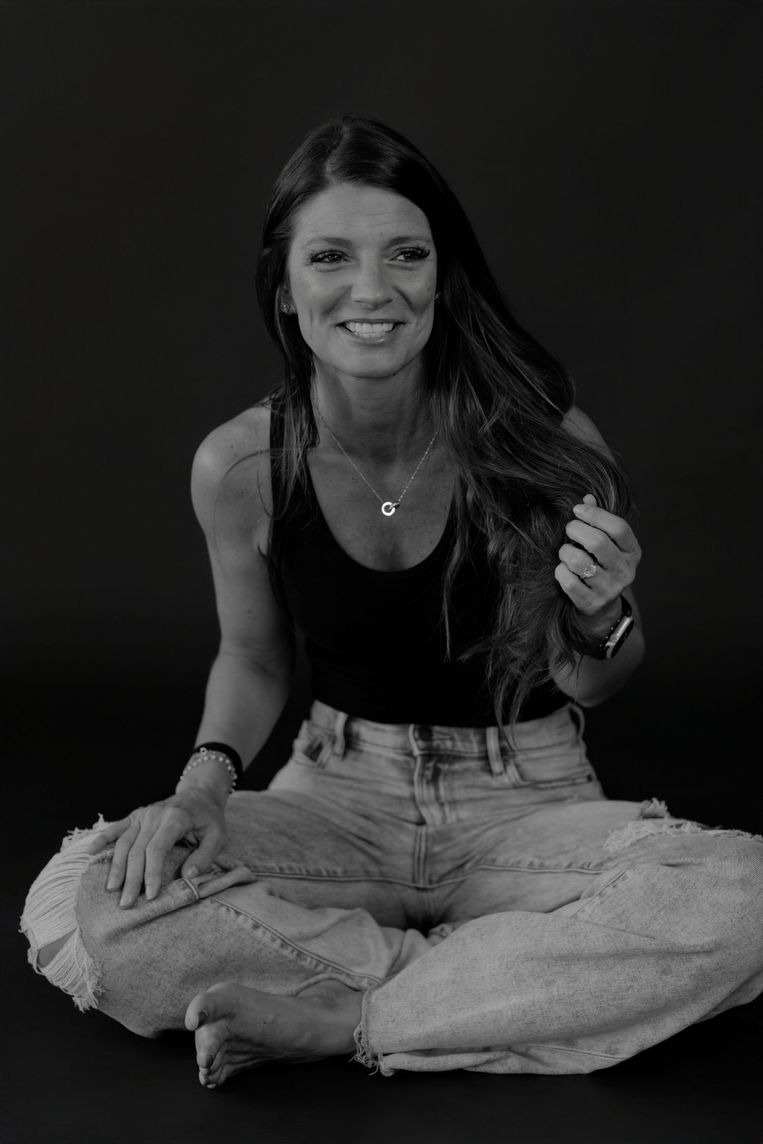 Black and white portrait series showing playful expressions against dark background with denim clothing.