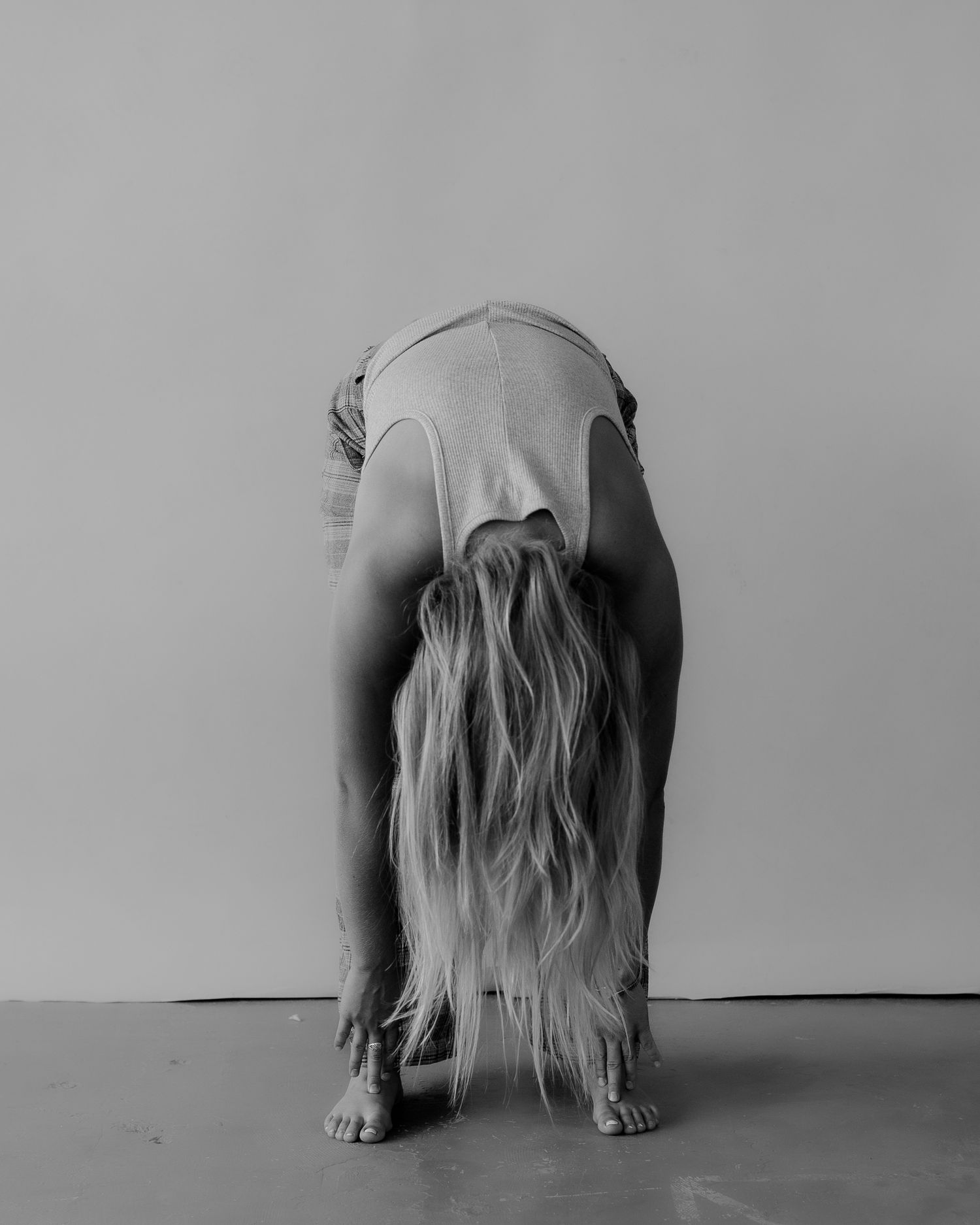 Moody black and white photo series showing person in minimalist setting with hair covering face.