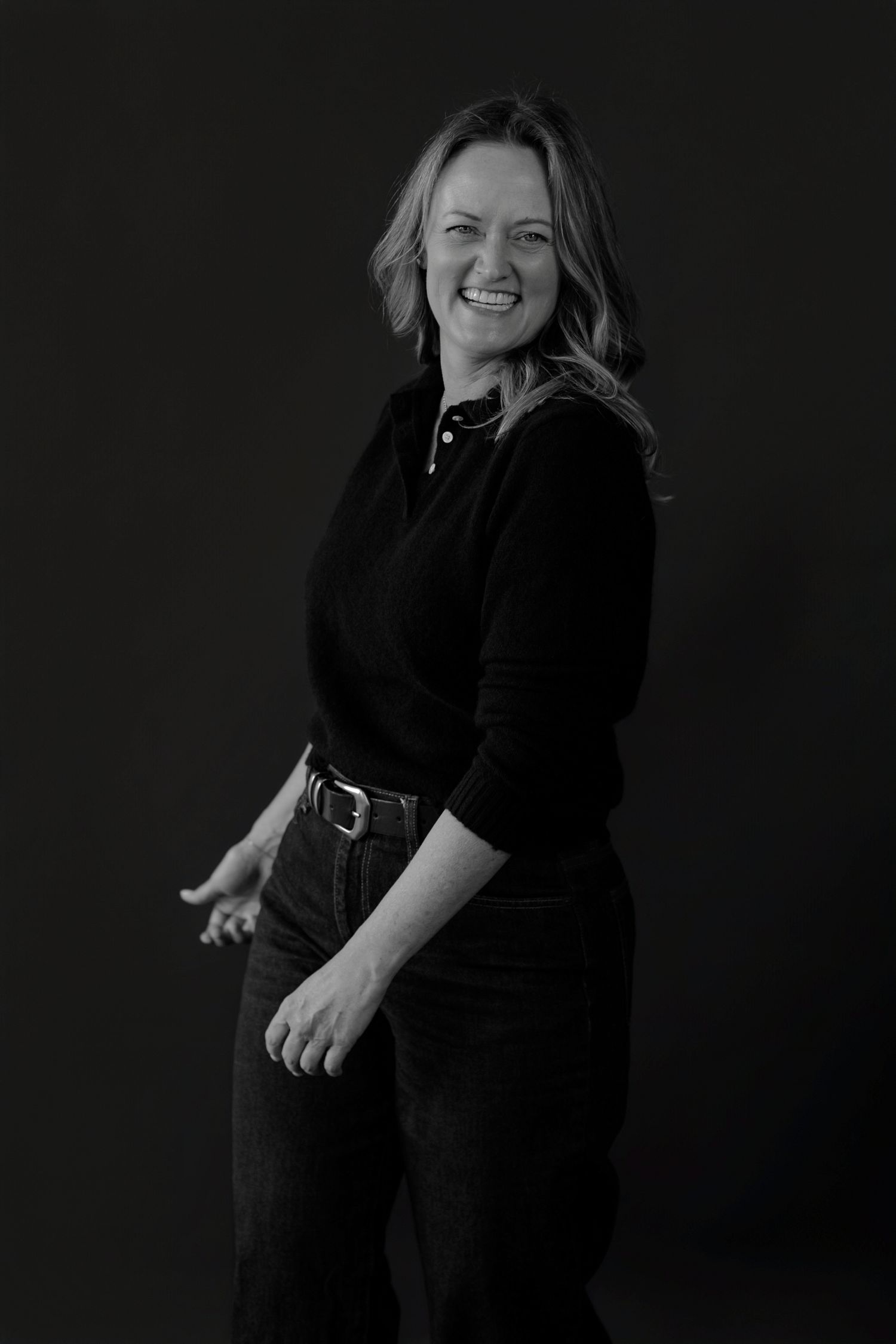 Candid black and white portrait sequence capturing natural laughter and movement.