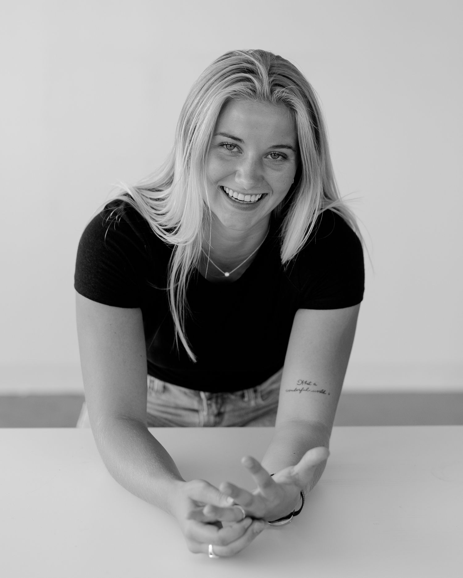 Black and white portraits showing playful expressions while leaning on a white surface.