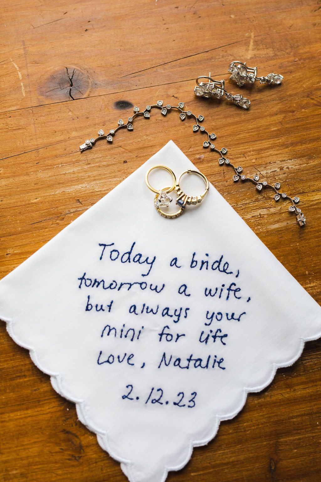Embroidered wedding handkerchief reading Today a bride tomorrow a wife but always your mini for life Love Natalie 2.12.23 with rings.