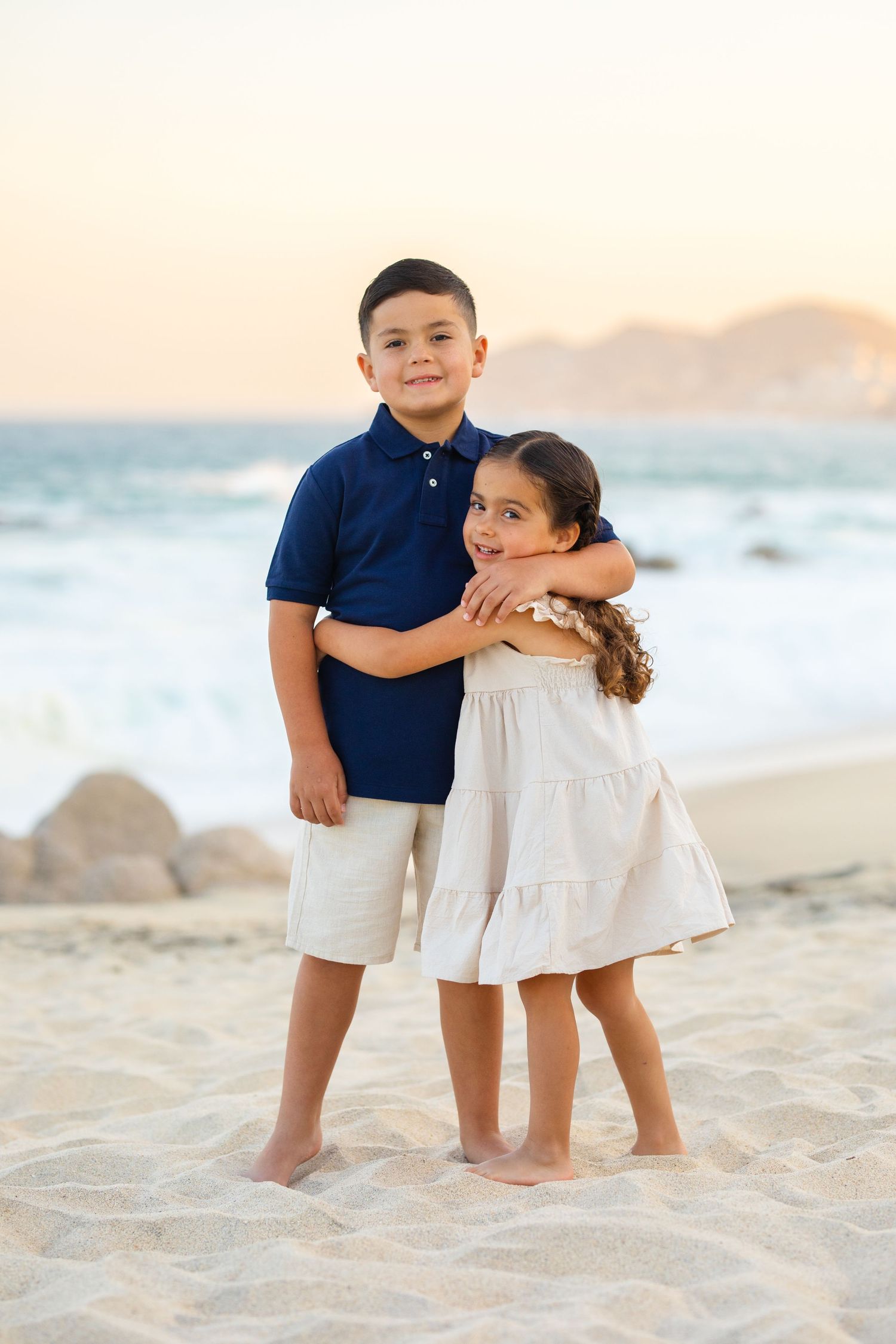 two kids embracing on beach in Cabo San Lucas