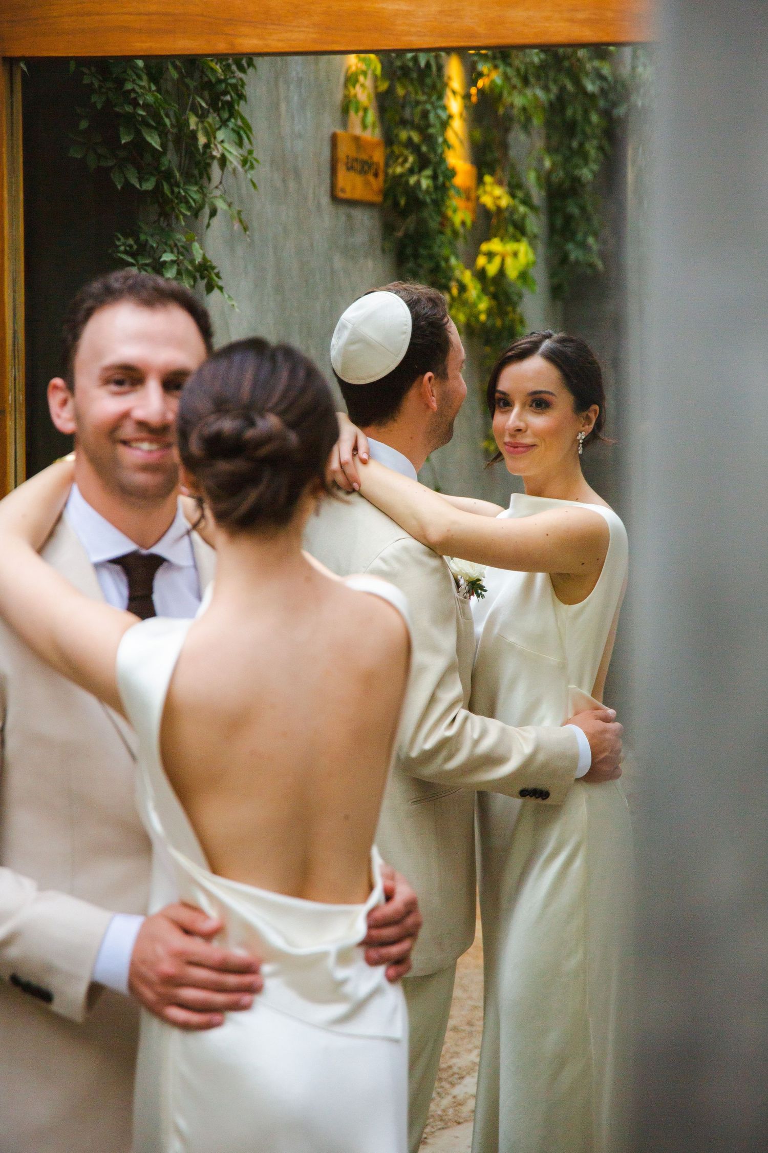 Two couples share a tender moment during what appears to be a Jewish wedding ceremony outdoors in Cabo at ACRE Resort