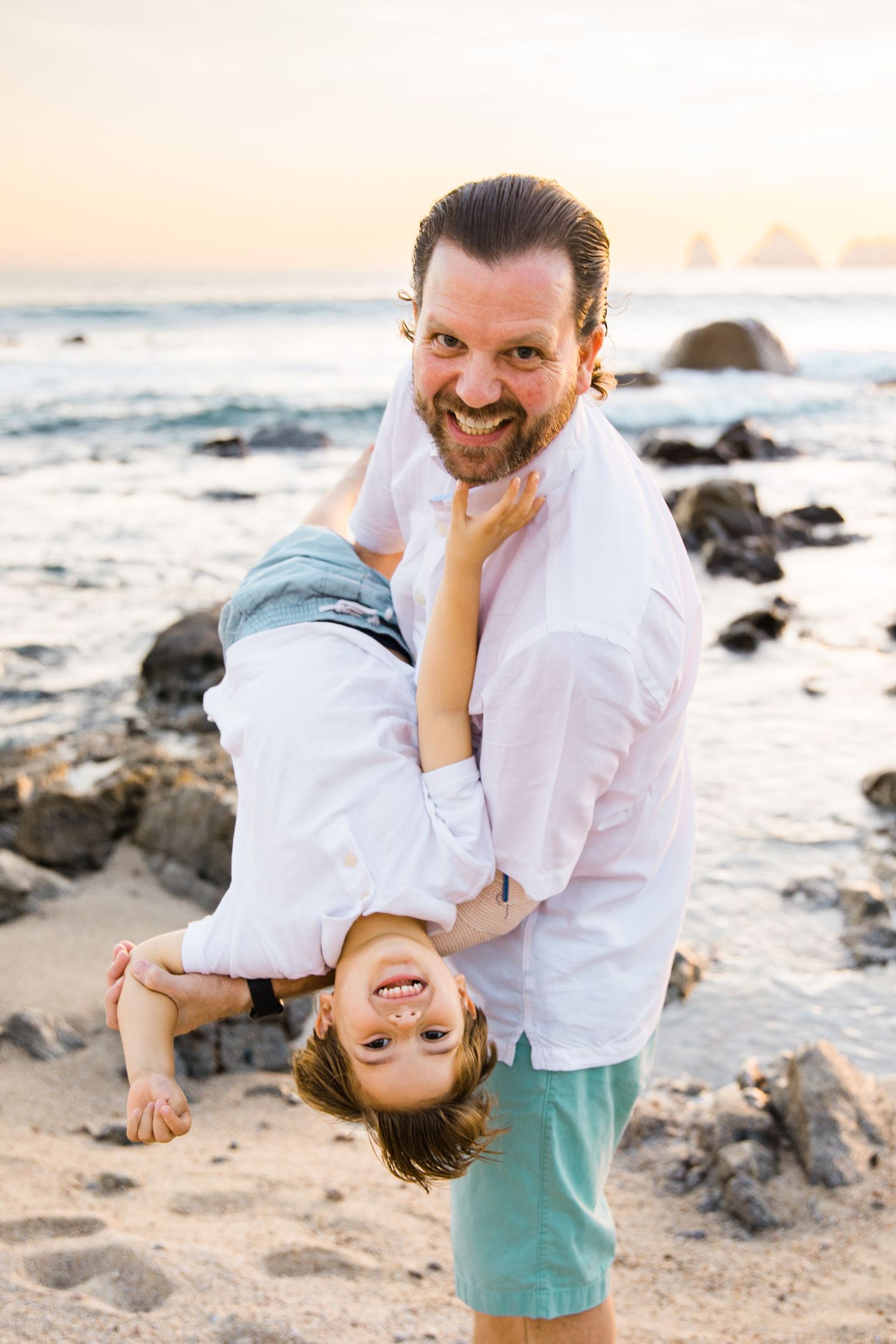 dad playing with son on the beach in Cabo San Lucas