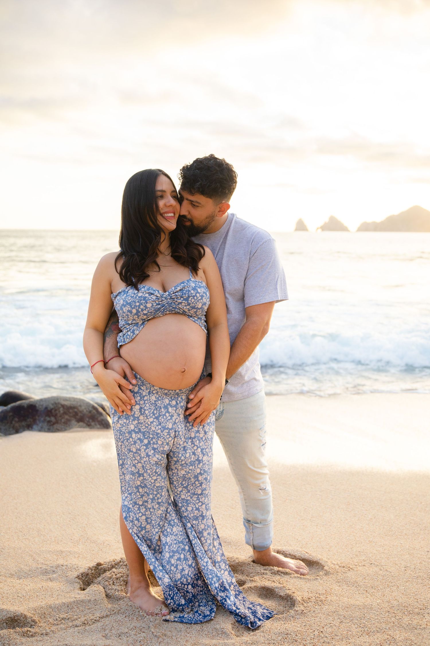pregnant couple in front of the Cabo San Lucas arch
