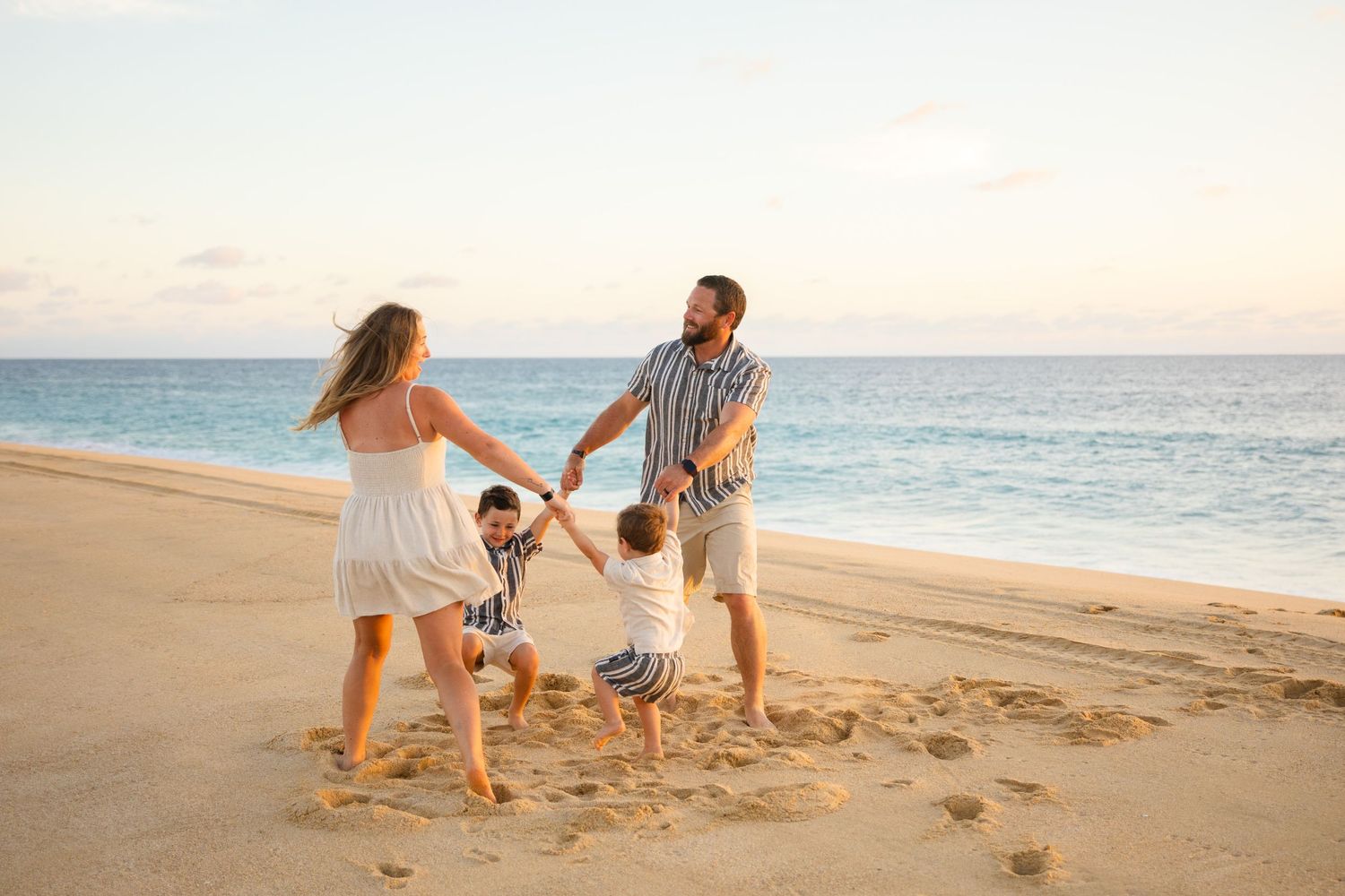family playing with child on beach in Cabo San Lucas