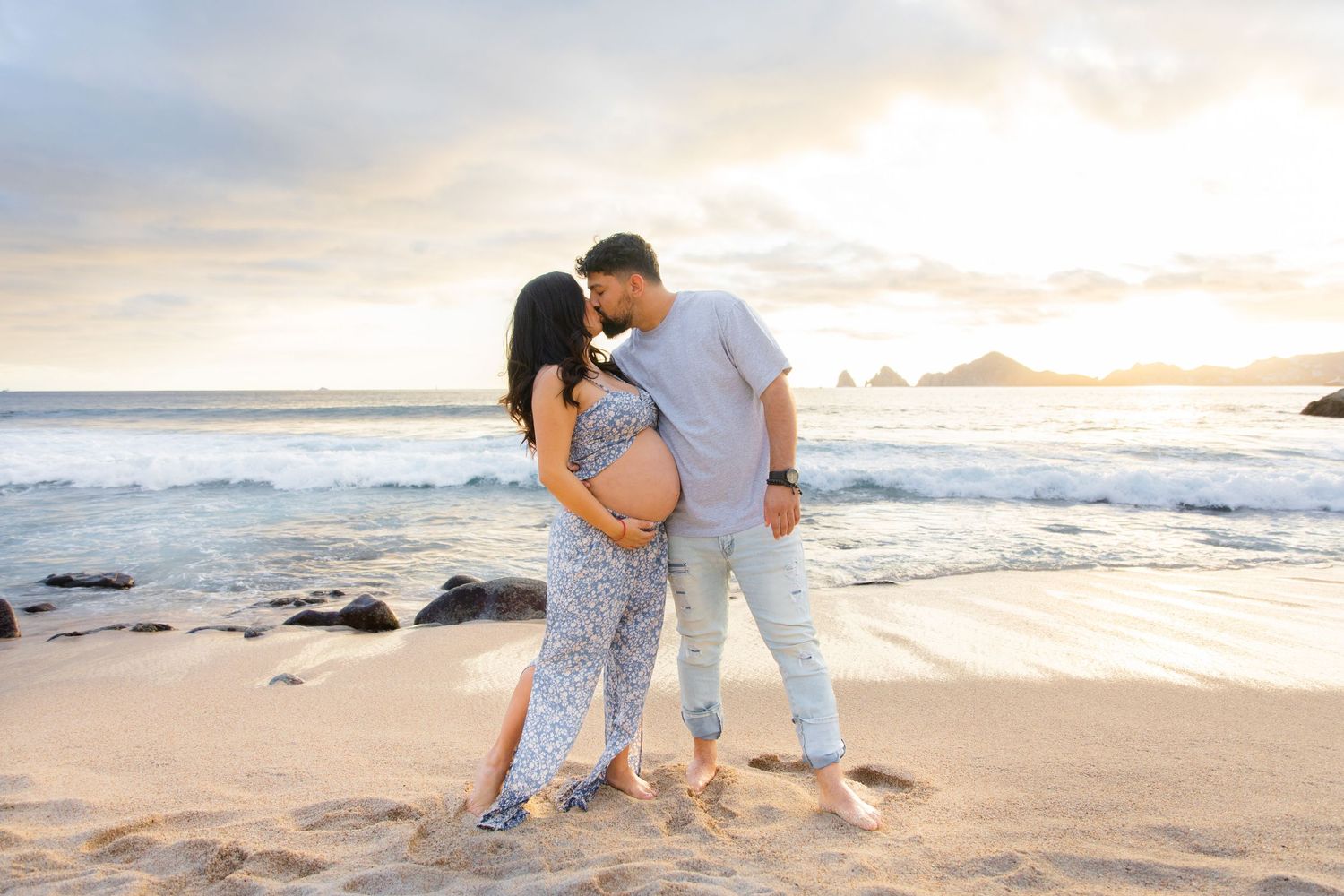 Couple sharing a tender moment on a sandy beach at sunset in Cabo San Lucas near sunset Mona Lisa restaurant