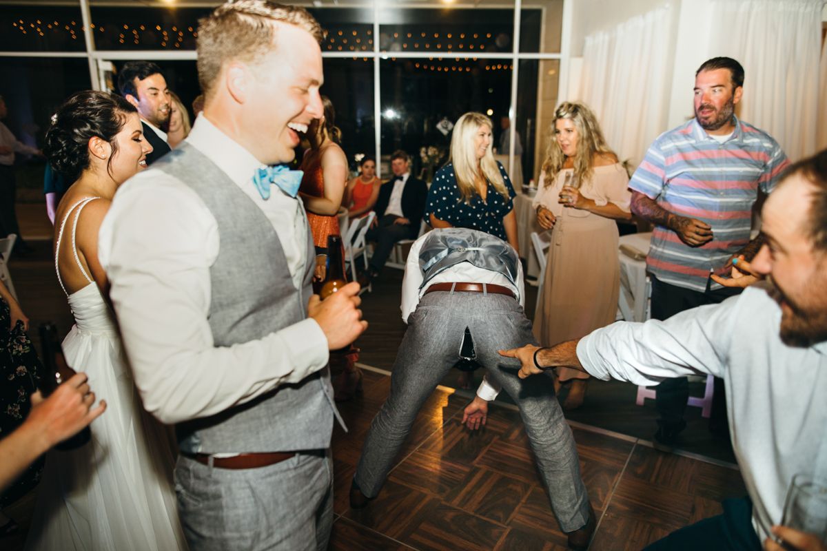 Wedding guests dancing energetically on reception dance floor in festive celebration.
