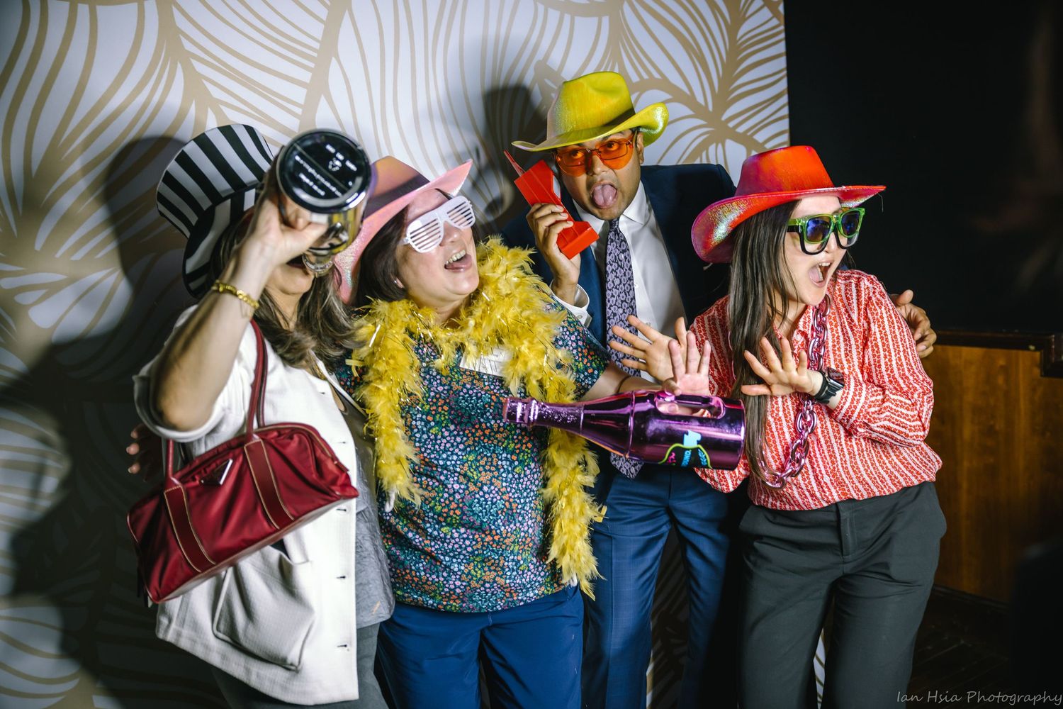 Group wearing colorful costumes and props posing for fun photo at event.