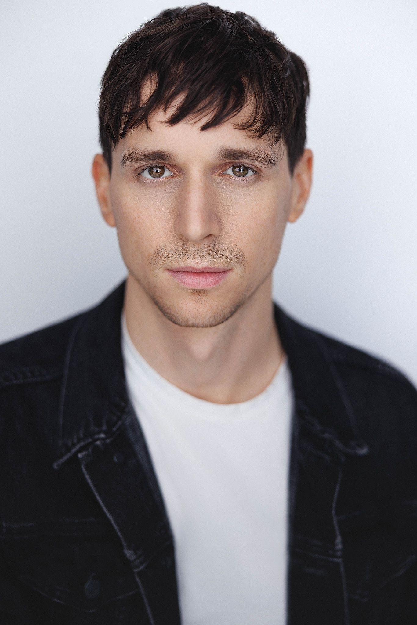A series of headshot portraits showing someone in a black jacket and white shirt against a light background.