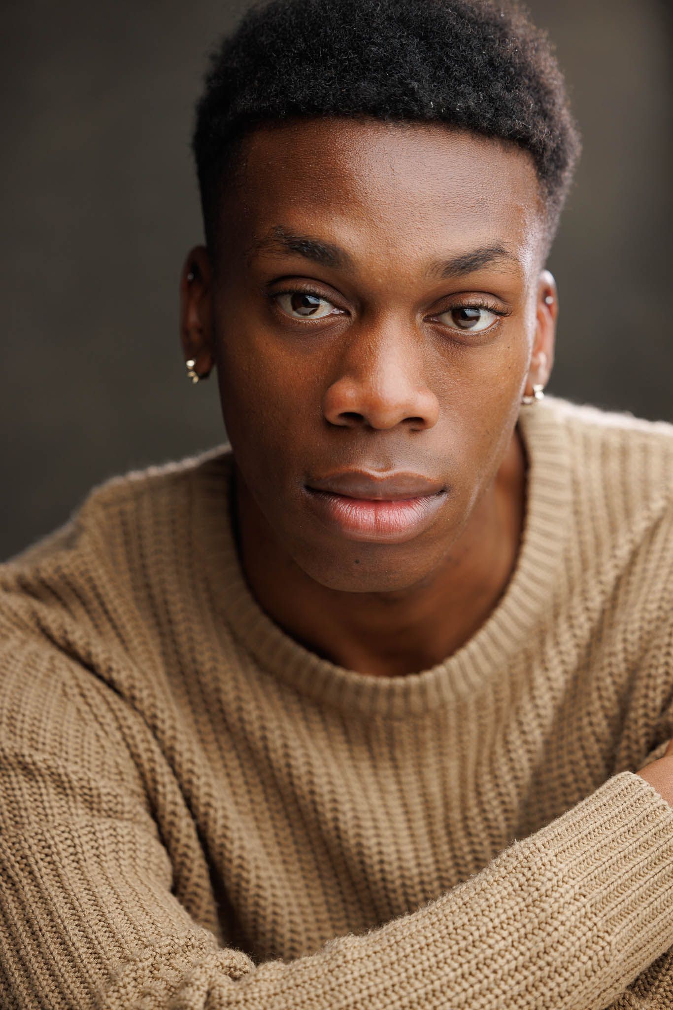 Studio portraits in a beige sweater.