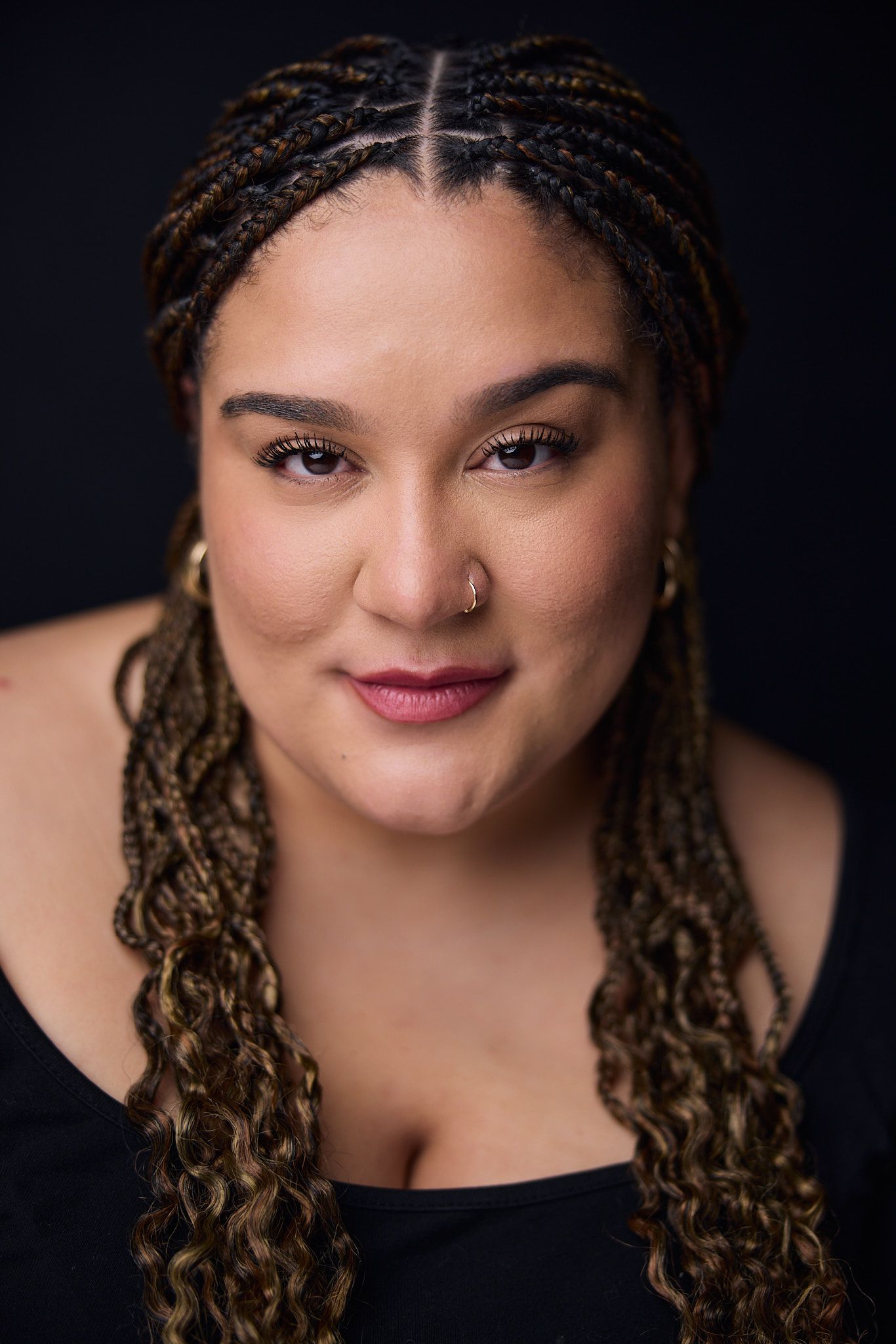Portrait series showing close-up views of a person with curly locs and nose piercing against a dark background.