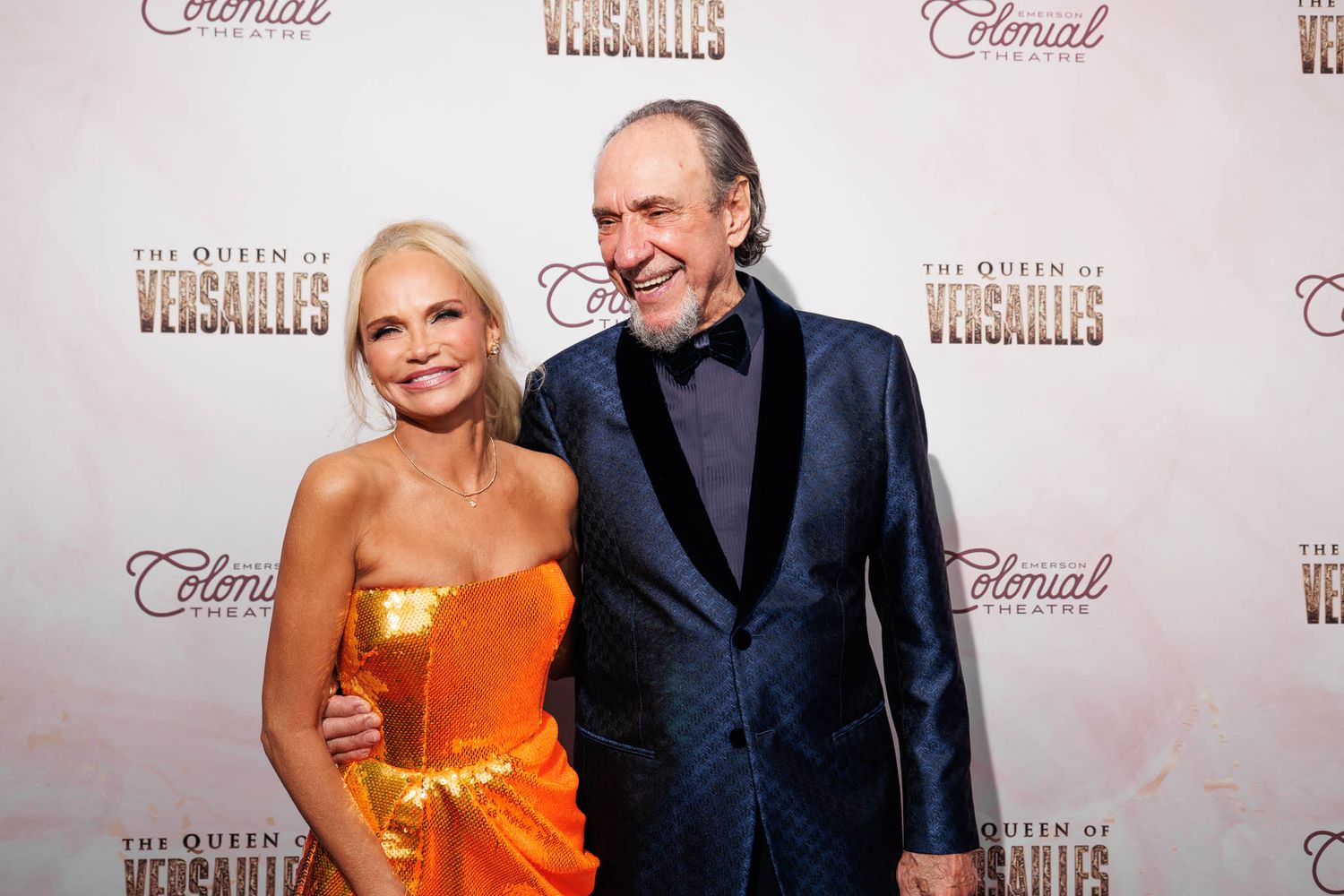 Red carpet event with attendees posing against branded backdrop.