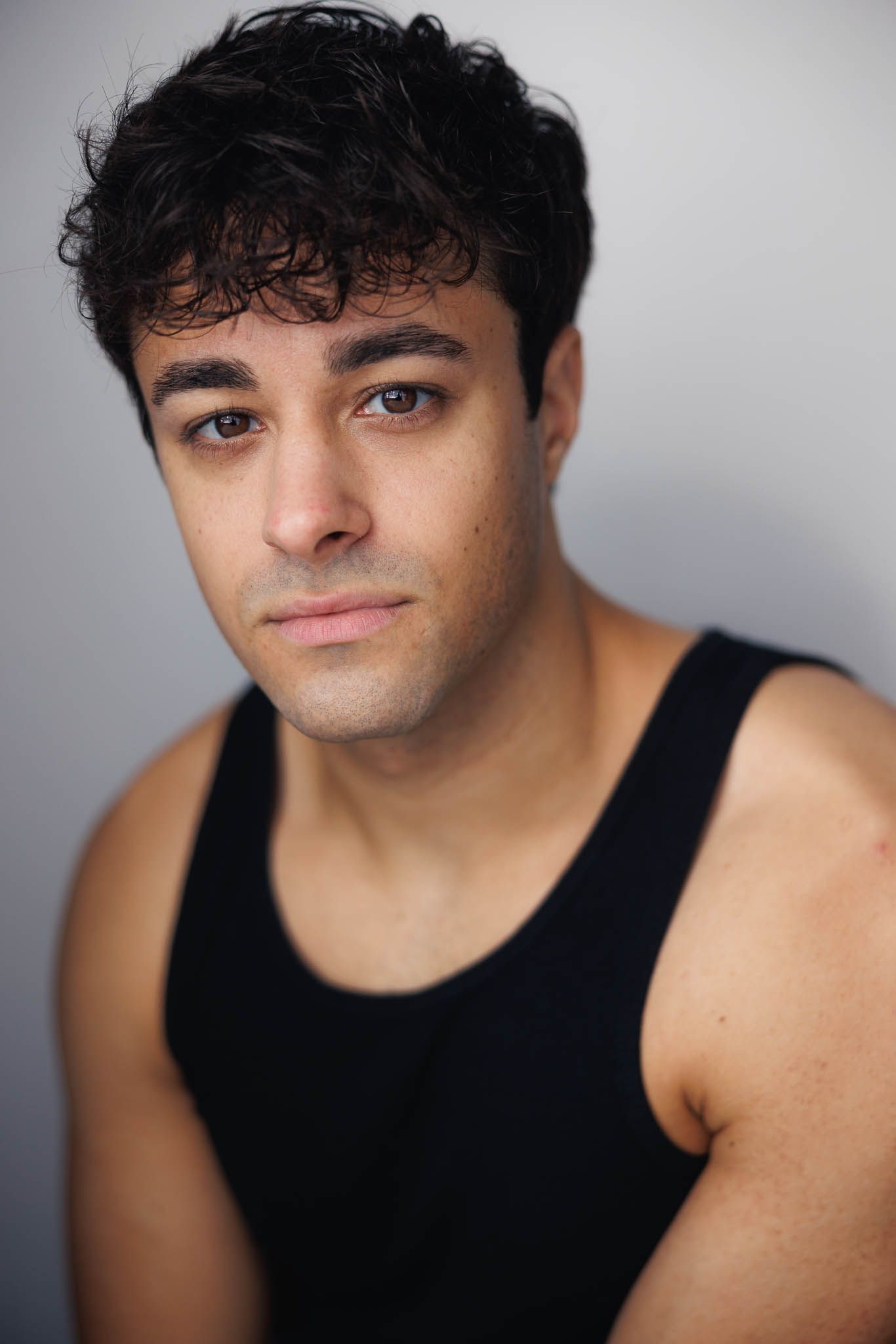 A series of headshots showing someone in a black tank top against a light gray background.