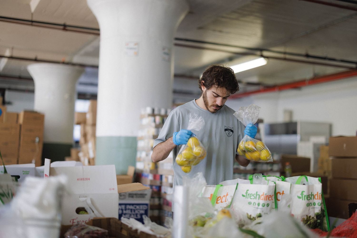 Workers sort through packages and boxes in a warehouse distribution center.