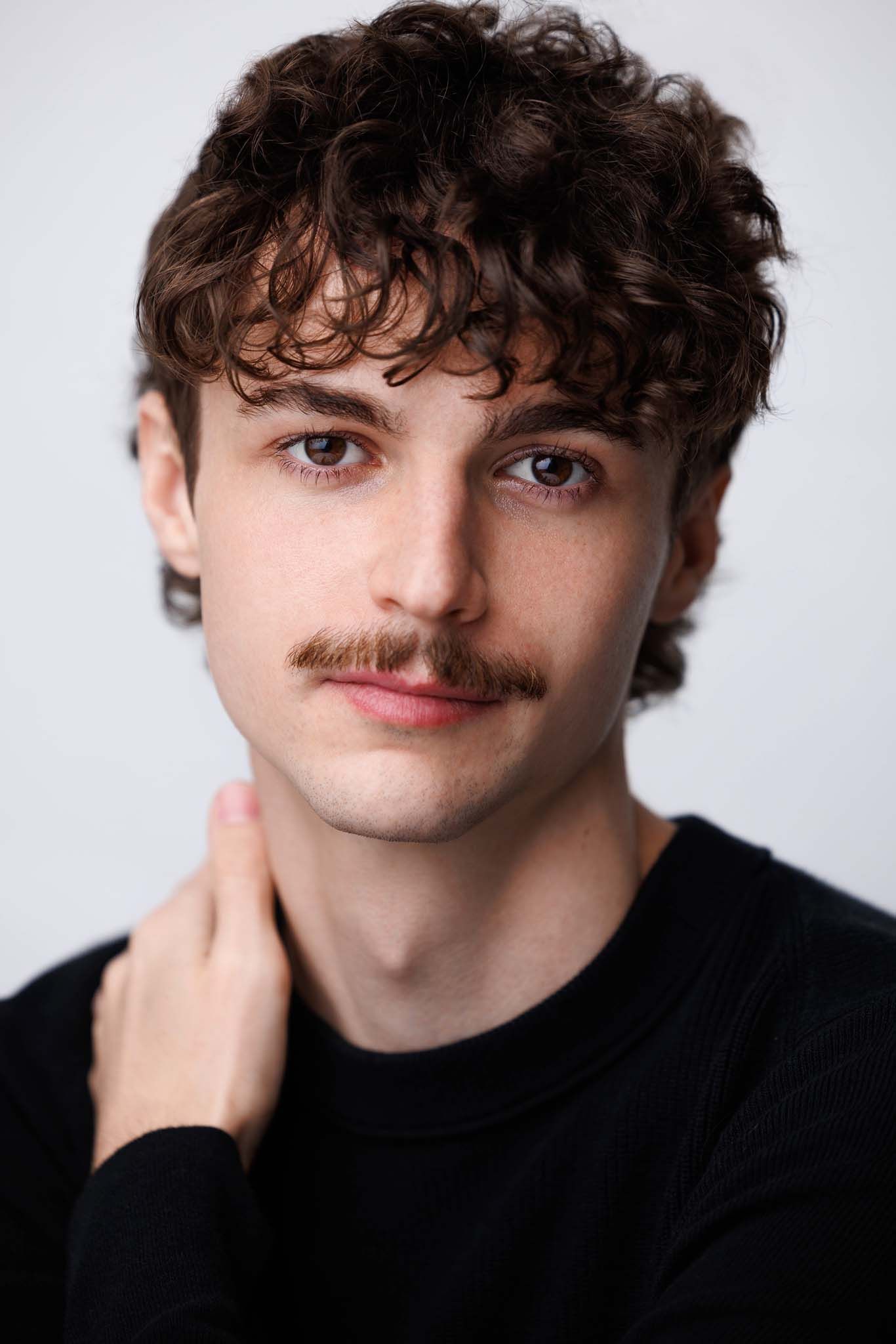 Headshot series showing various poses in white shirt against light background.