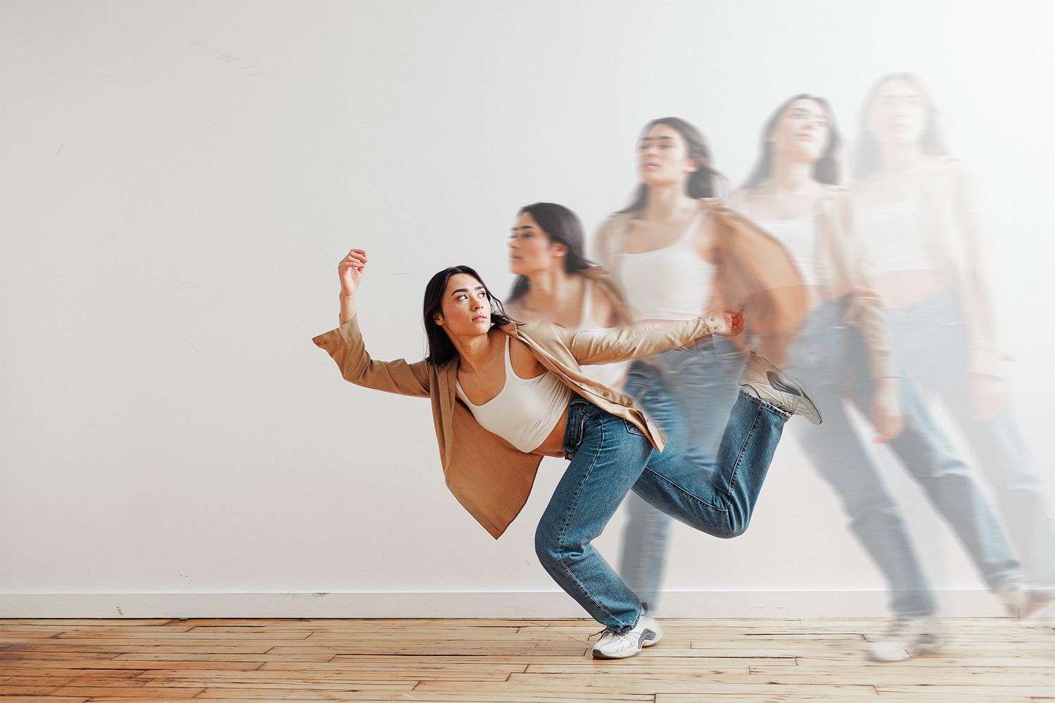 Dance class participants practicing dynamic movements in bright studio space.