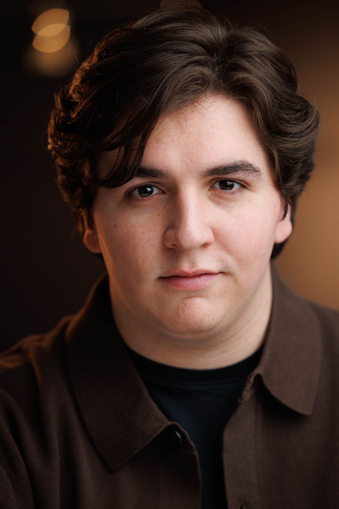 Series of close-up portraits in dark clothing against warm background lighting.