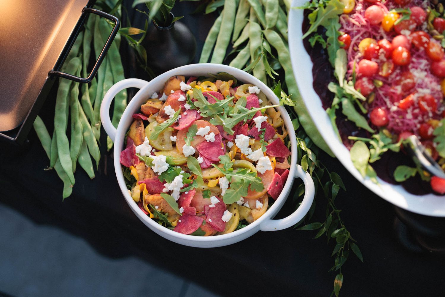 Fresh poke bowls with raw tuna, green onions, and garnishes arranged in white bowls on a dark surface.